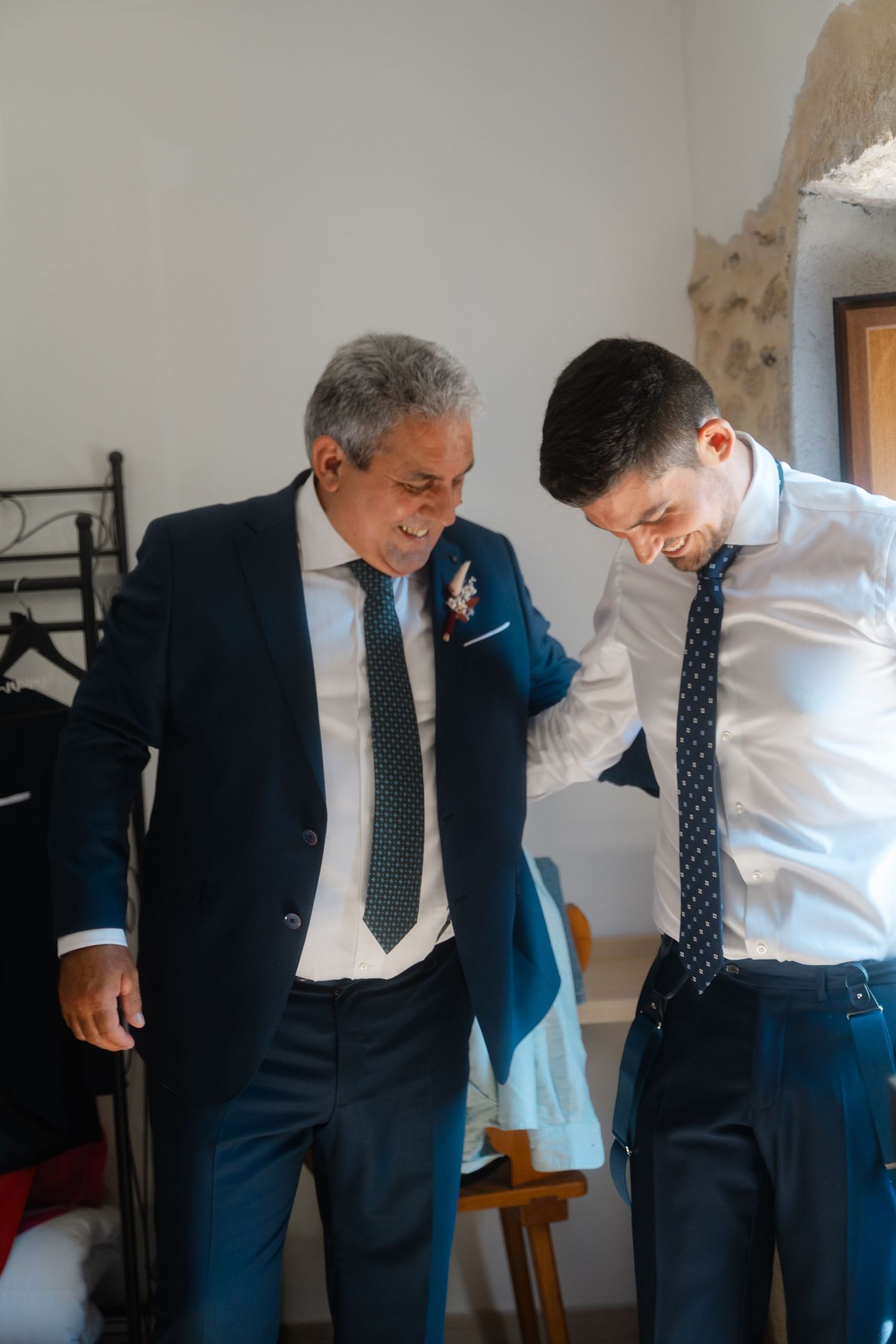 Two people in suits share a lighthearted moment while getting ready, captured in a sequence of candid shots.