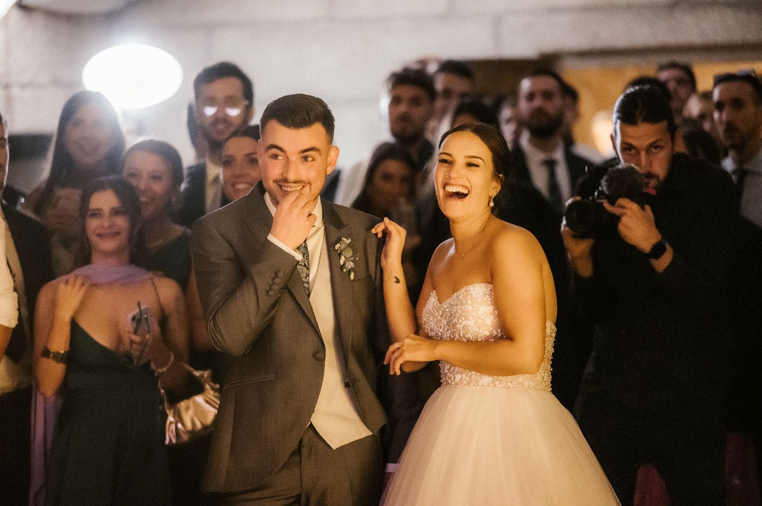 Wedding guests dance and celebrate on a crowded dance floor at an evening reception.