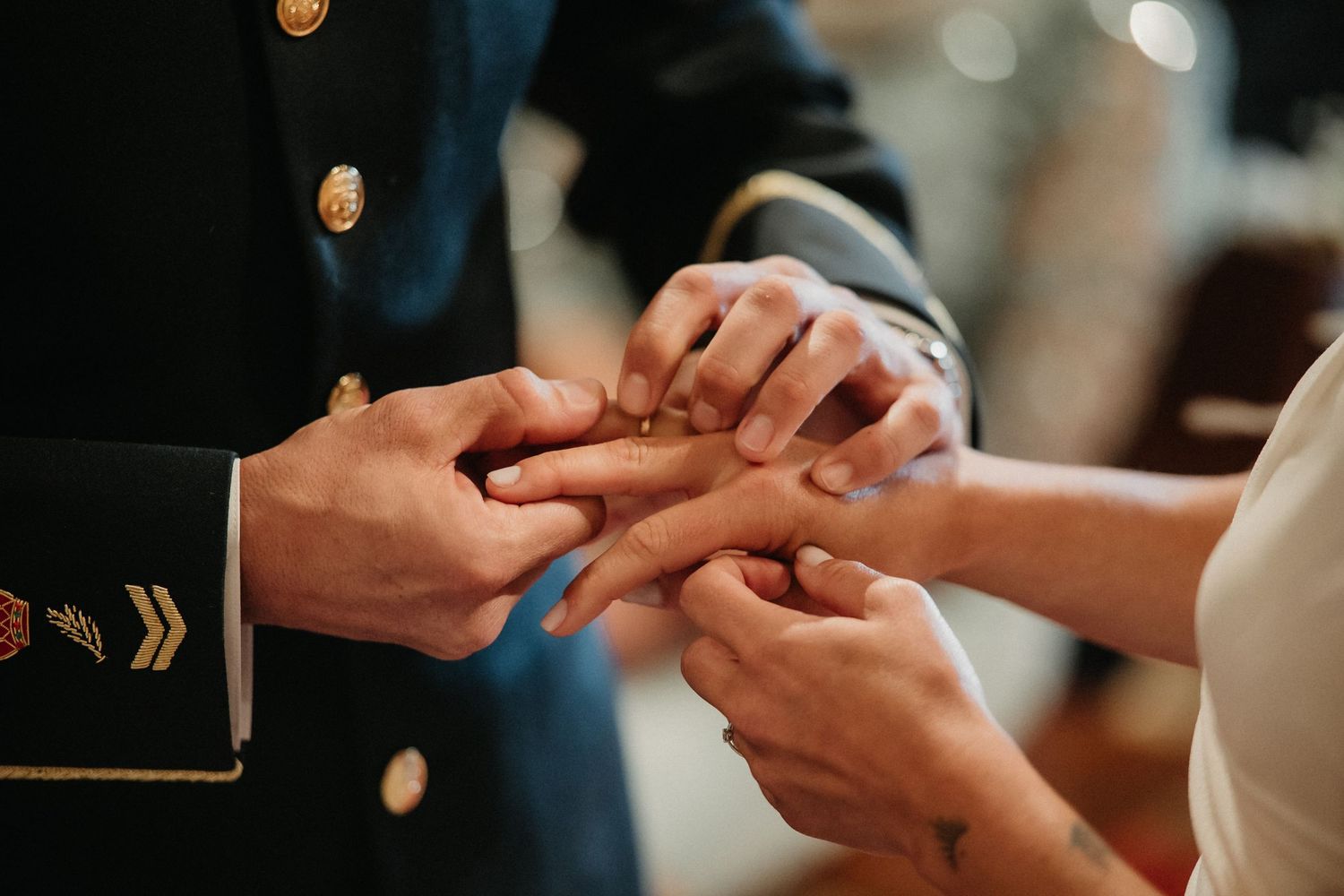 Close-up of hands exchanging wedding rings during an intimate ceremony.