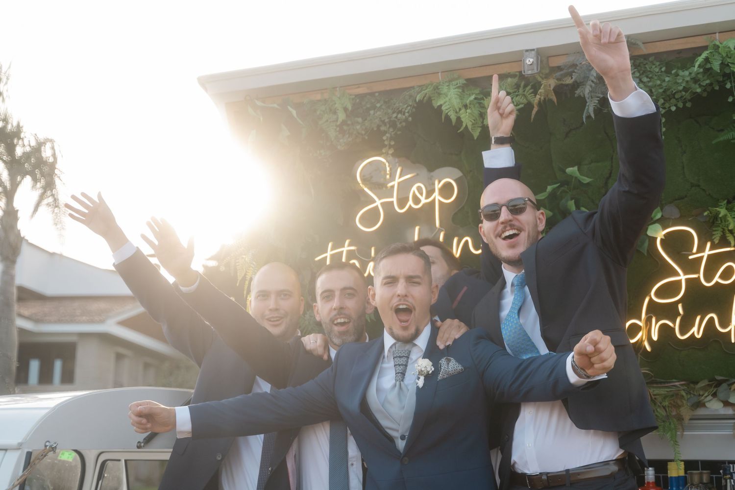 Celebratory group raises hands in excitement at an outdoor event.