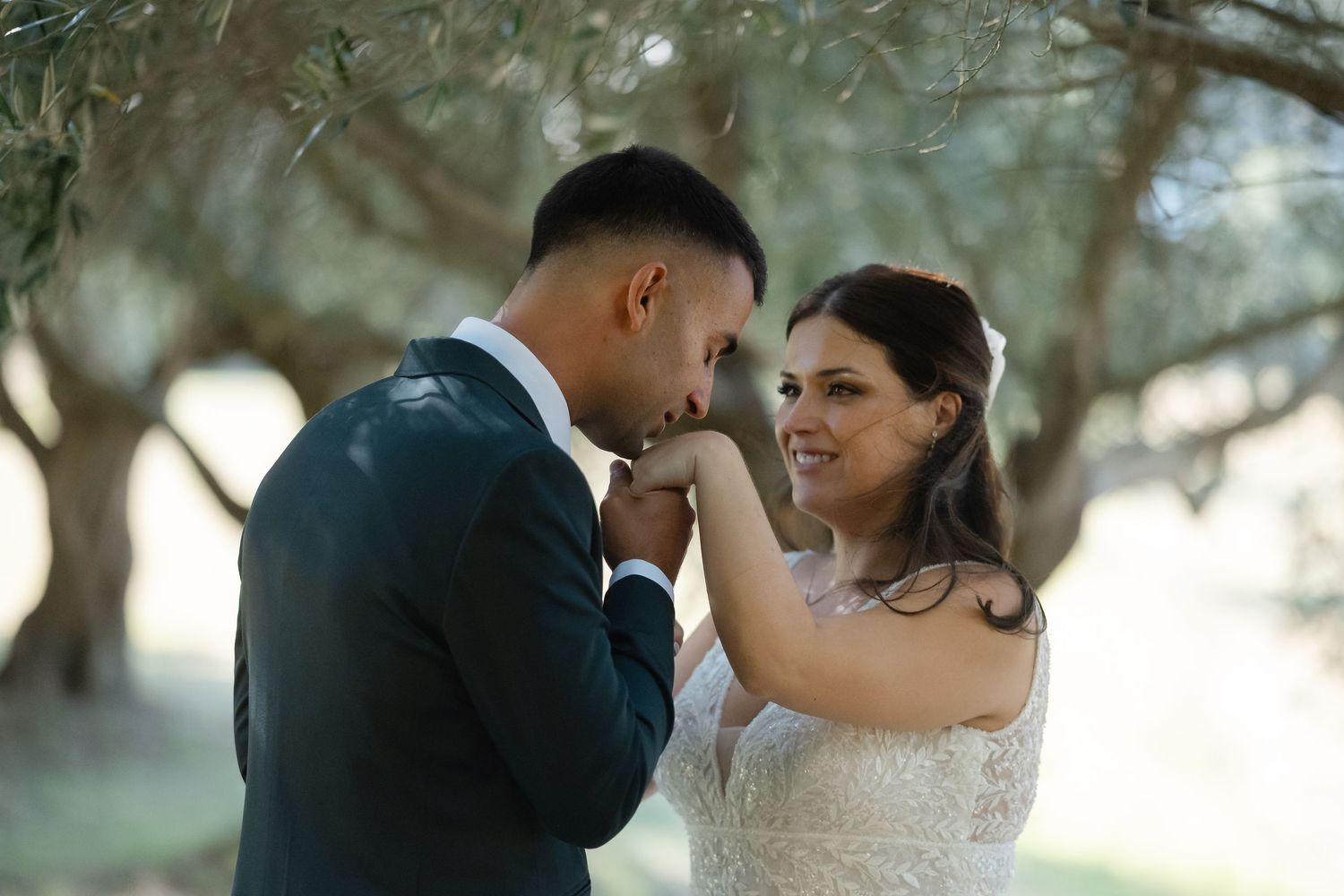 A romantic couple in wedding attire shares intimate moments in a dreamy outdoor setting with soft natural lighting.