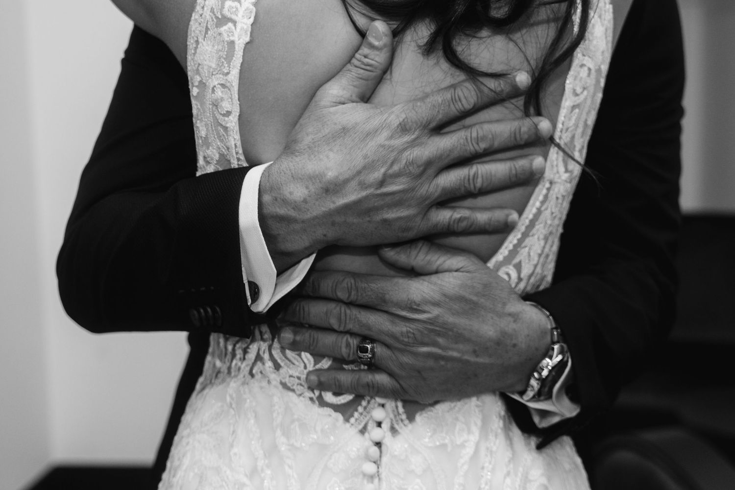 Close-up of formal attire showing detailed lace and fabric textures in black and white.