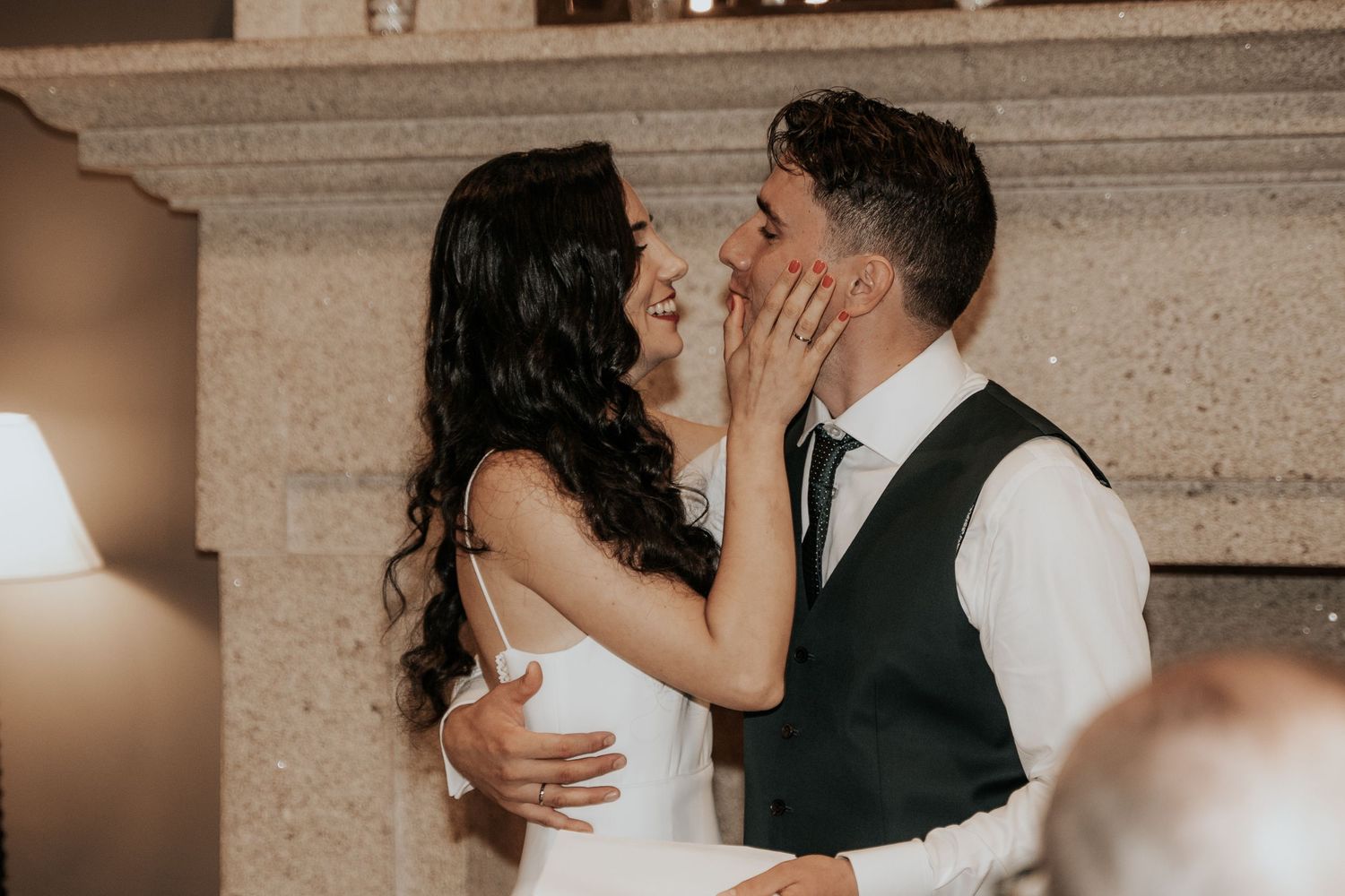 A romantic wedding moment captured in warm lighting with a couple sharing an intimate embrace during their first dance.