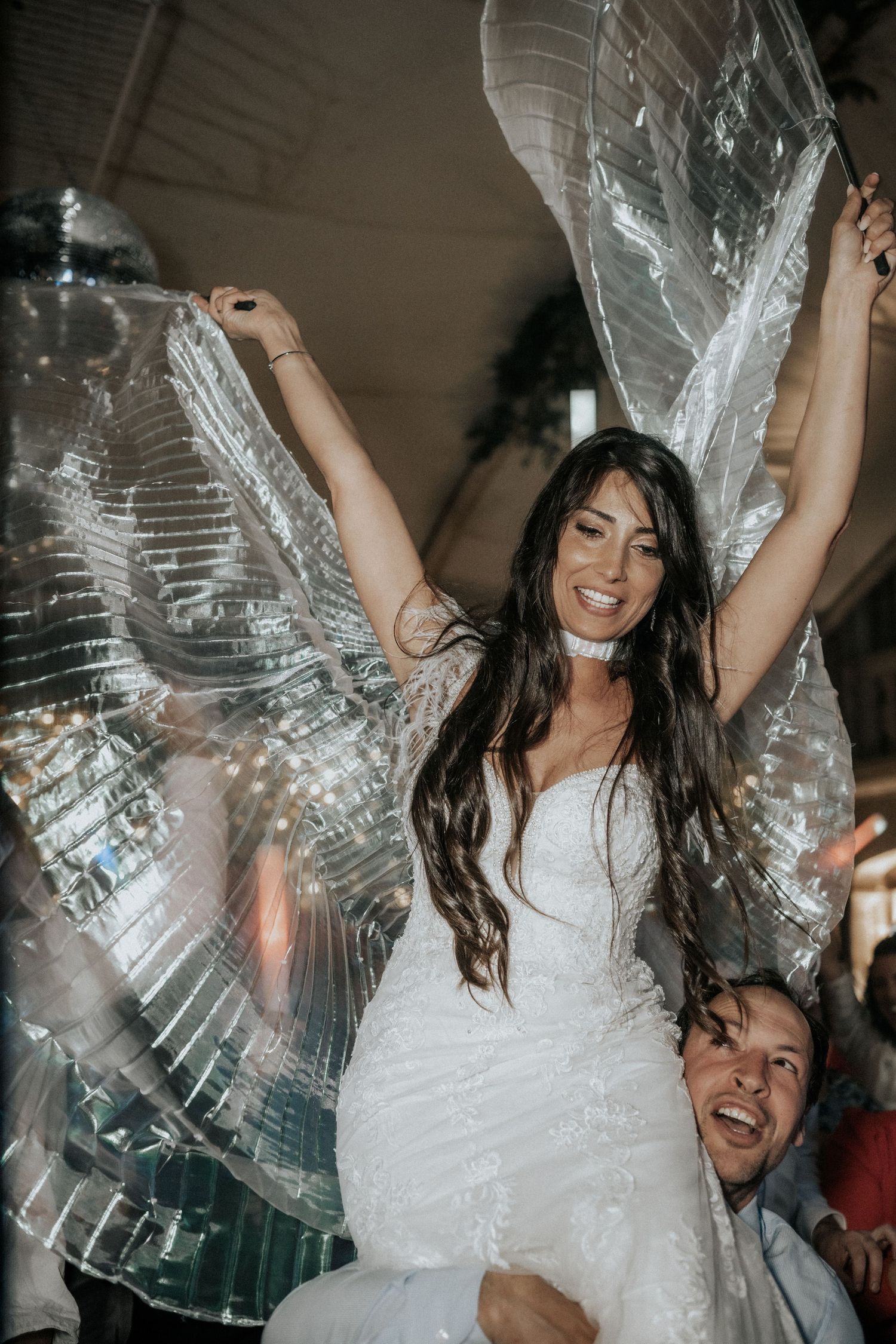 Joyful celebration sequence showing someone in a white wedding dress dancing with a clear bubble zorb ball at a reception.