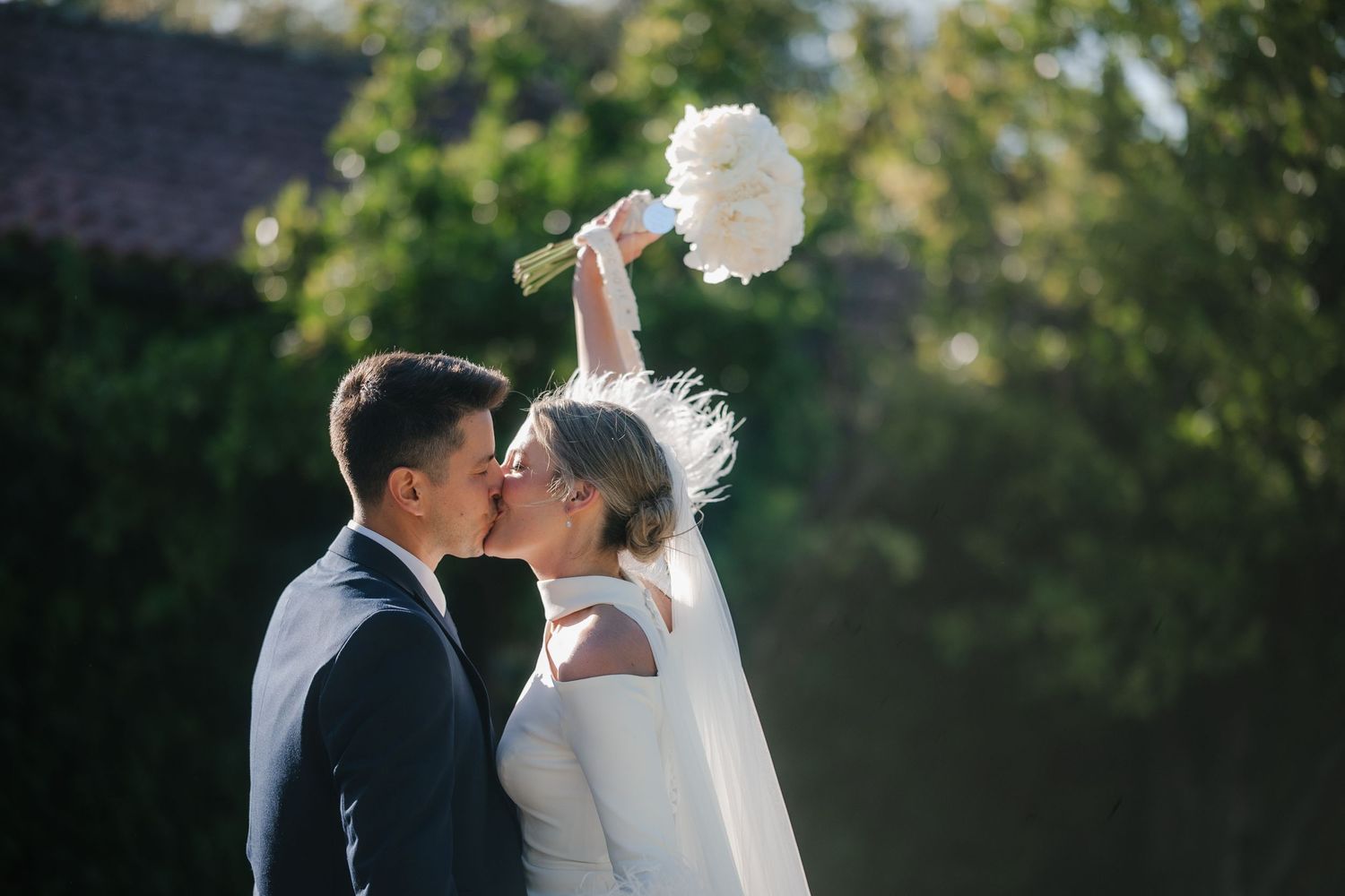 A romantic wedding couple shares tender moments in a garden setting during their outdoor photo session.