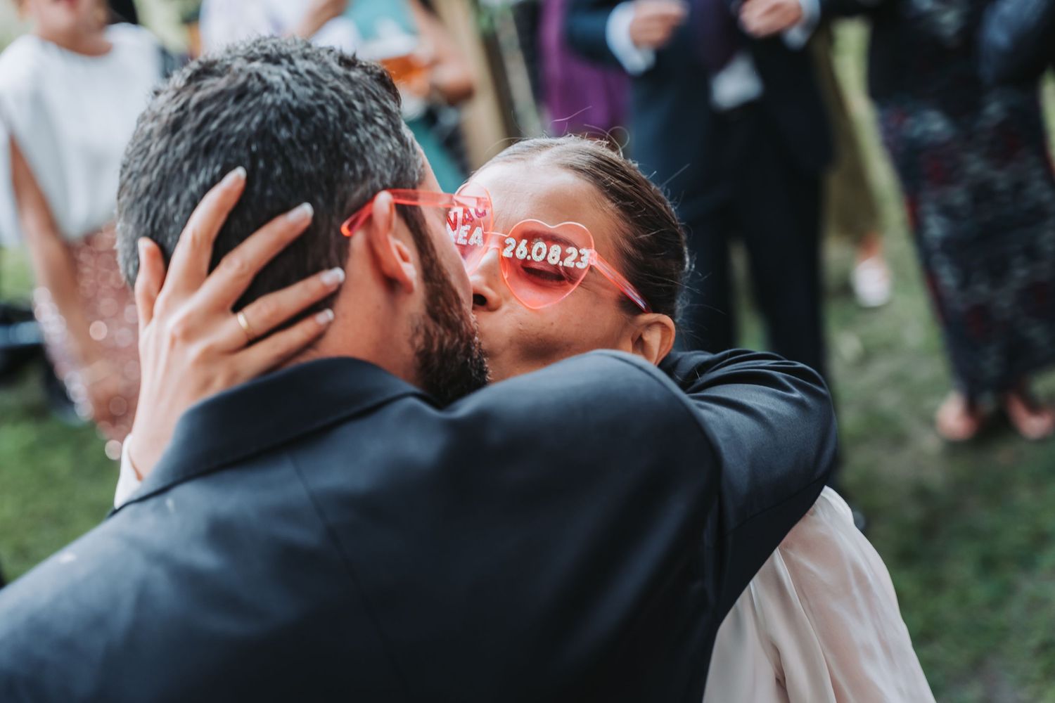 A series of emotional embraces between people at an outdoor gathering, showing warmth and connection.