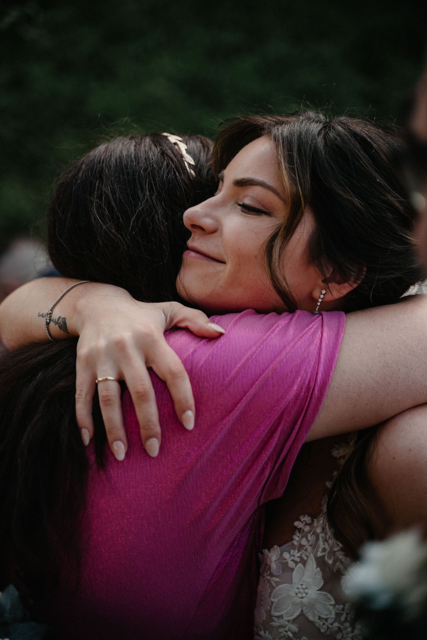 Two people share an emotional embrace wearing a pink shirt and white dress in a sequence of candid photos.