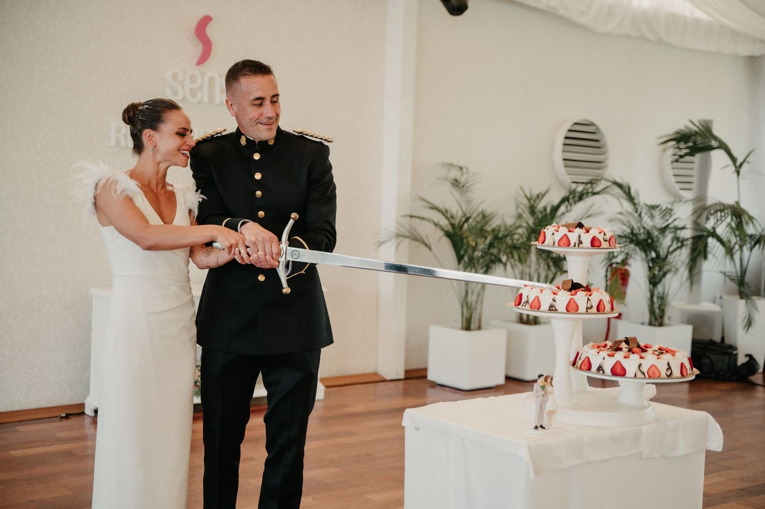 A wedding cake cutting sequence showing the couple slicing into a white tiered cake with red decorations.