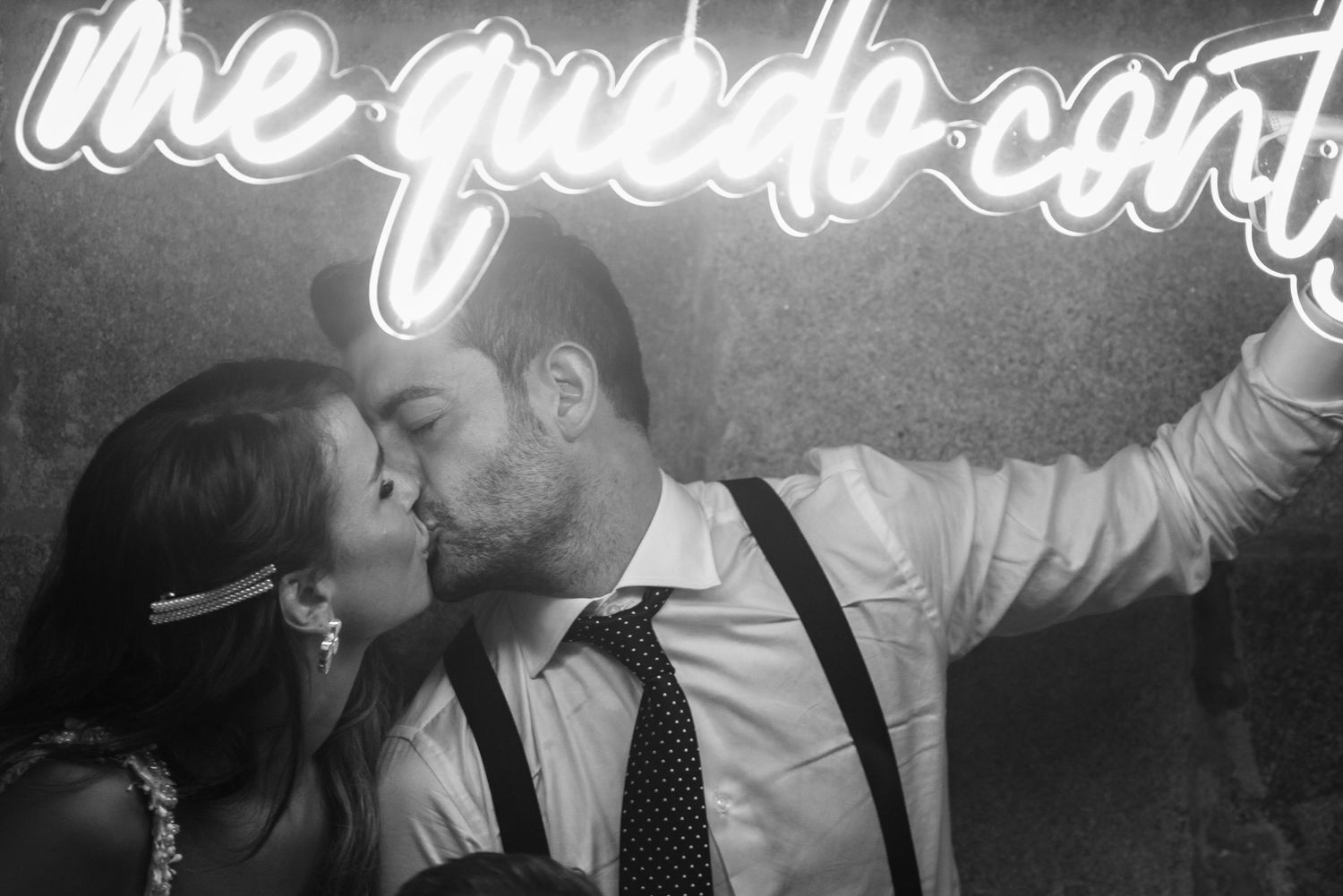 Black and white photo of performers playing music with neon text overlaid above.