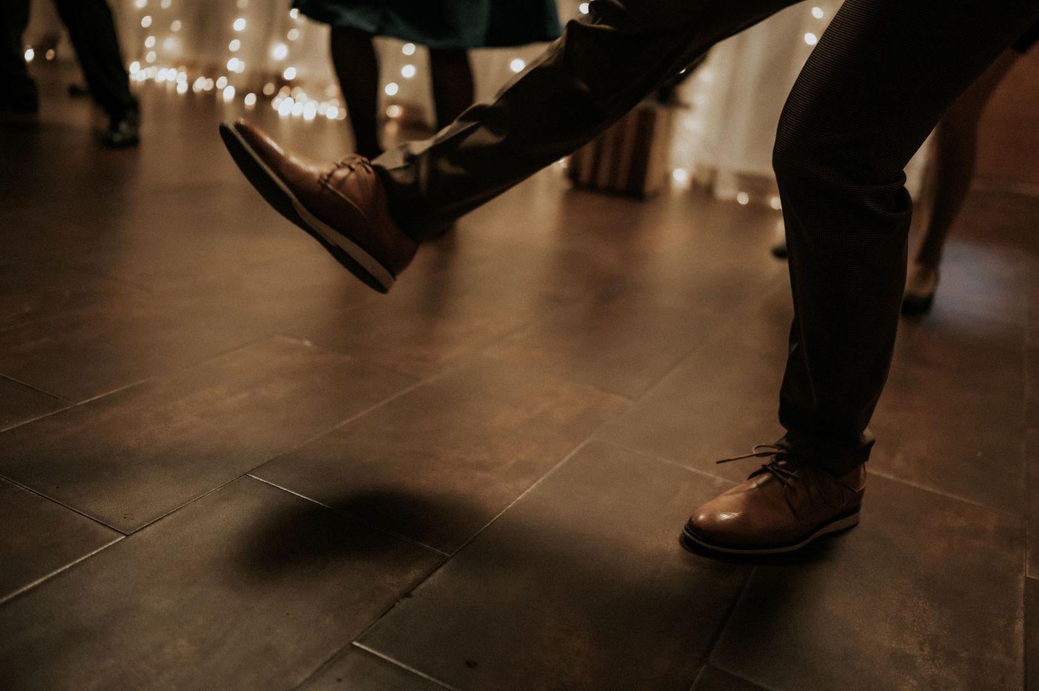 Red shoes and formal attire visible on a dark wooden dance floor.