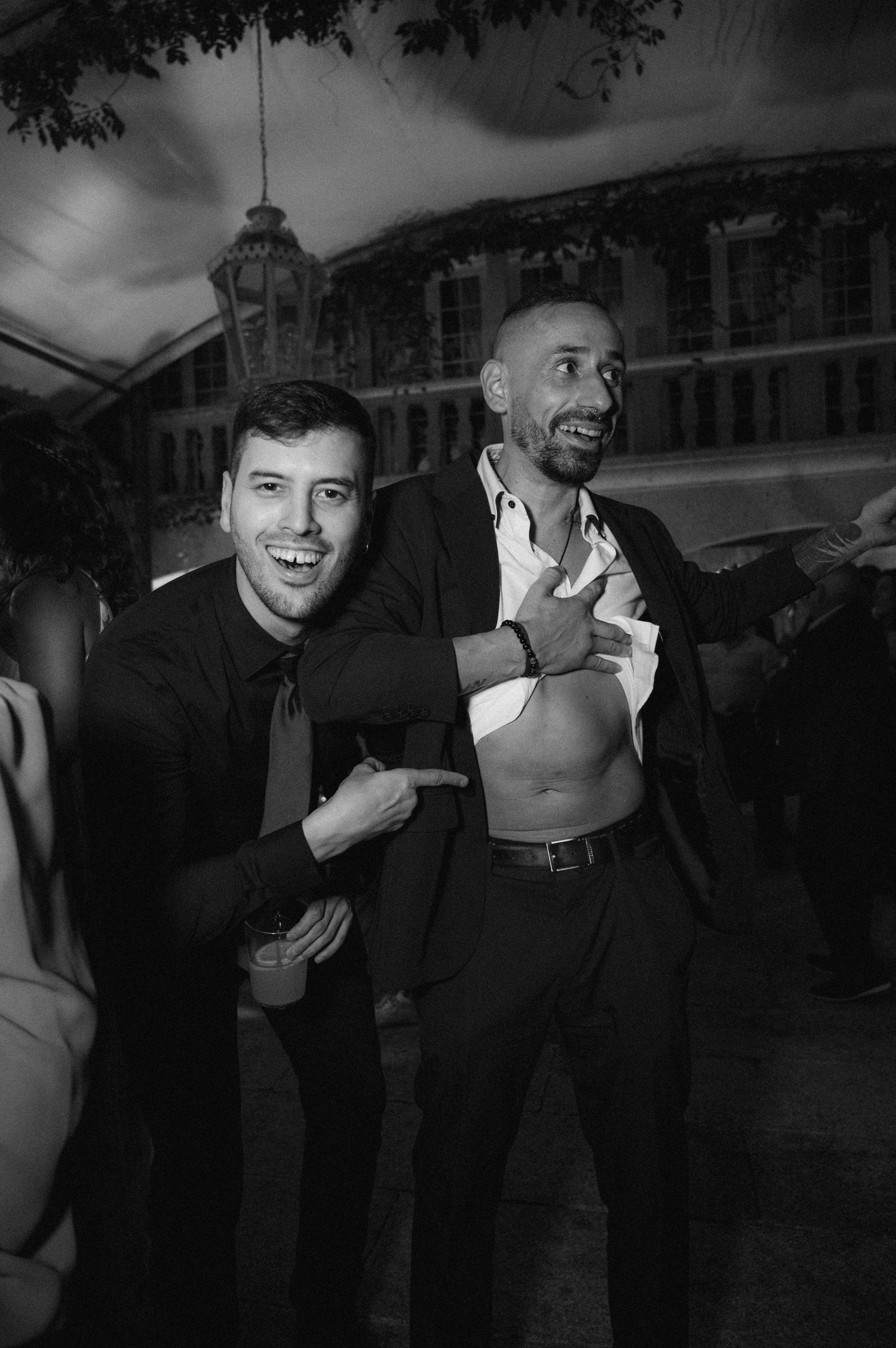 Black and white candid shots of guests laughing and enjoying themselves at a social gathering.