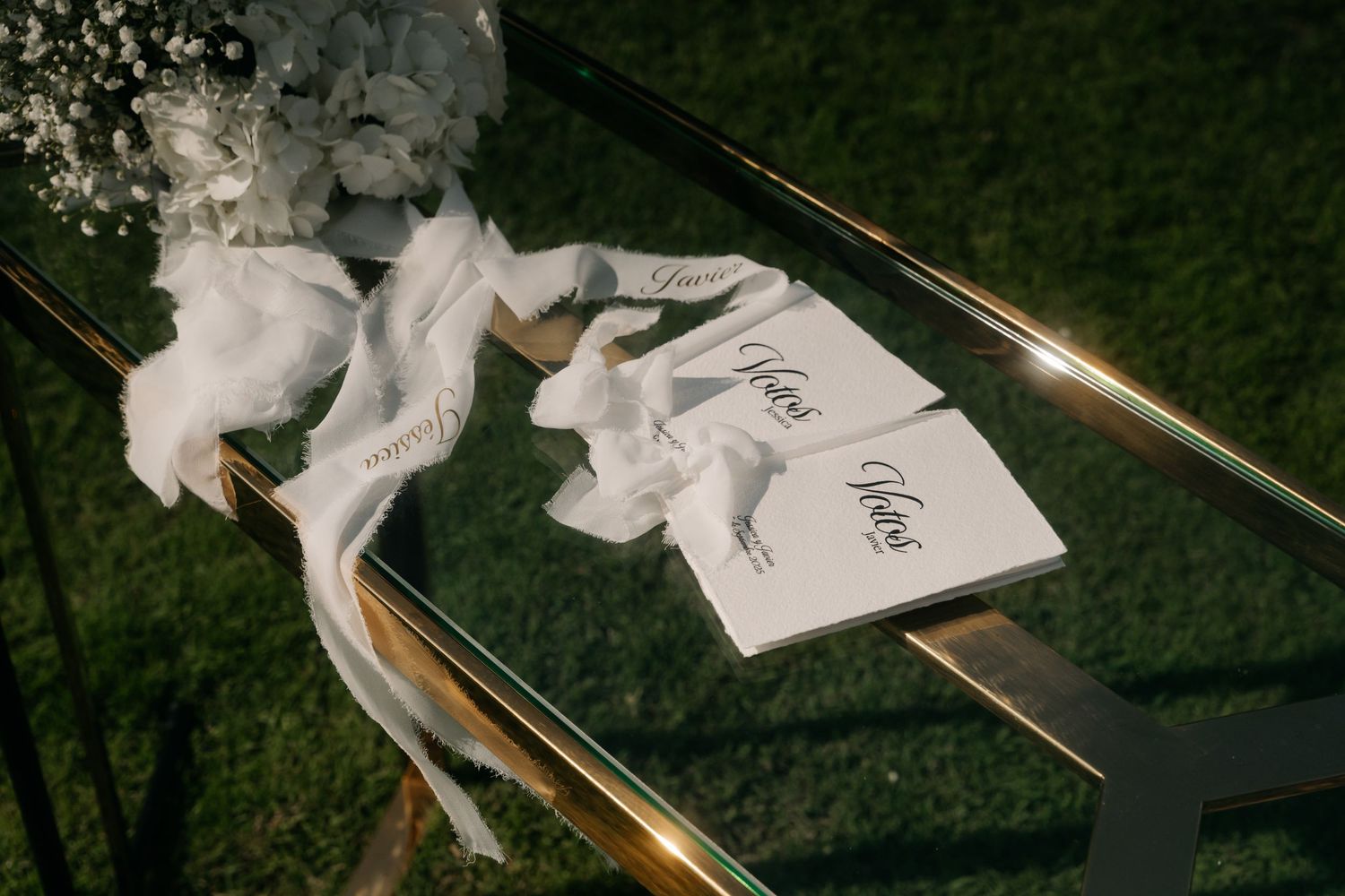 Wedding vow books tied with silk ribbon rest on a metallic railing at dusk.Wedding photographer Spain. Galicia.