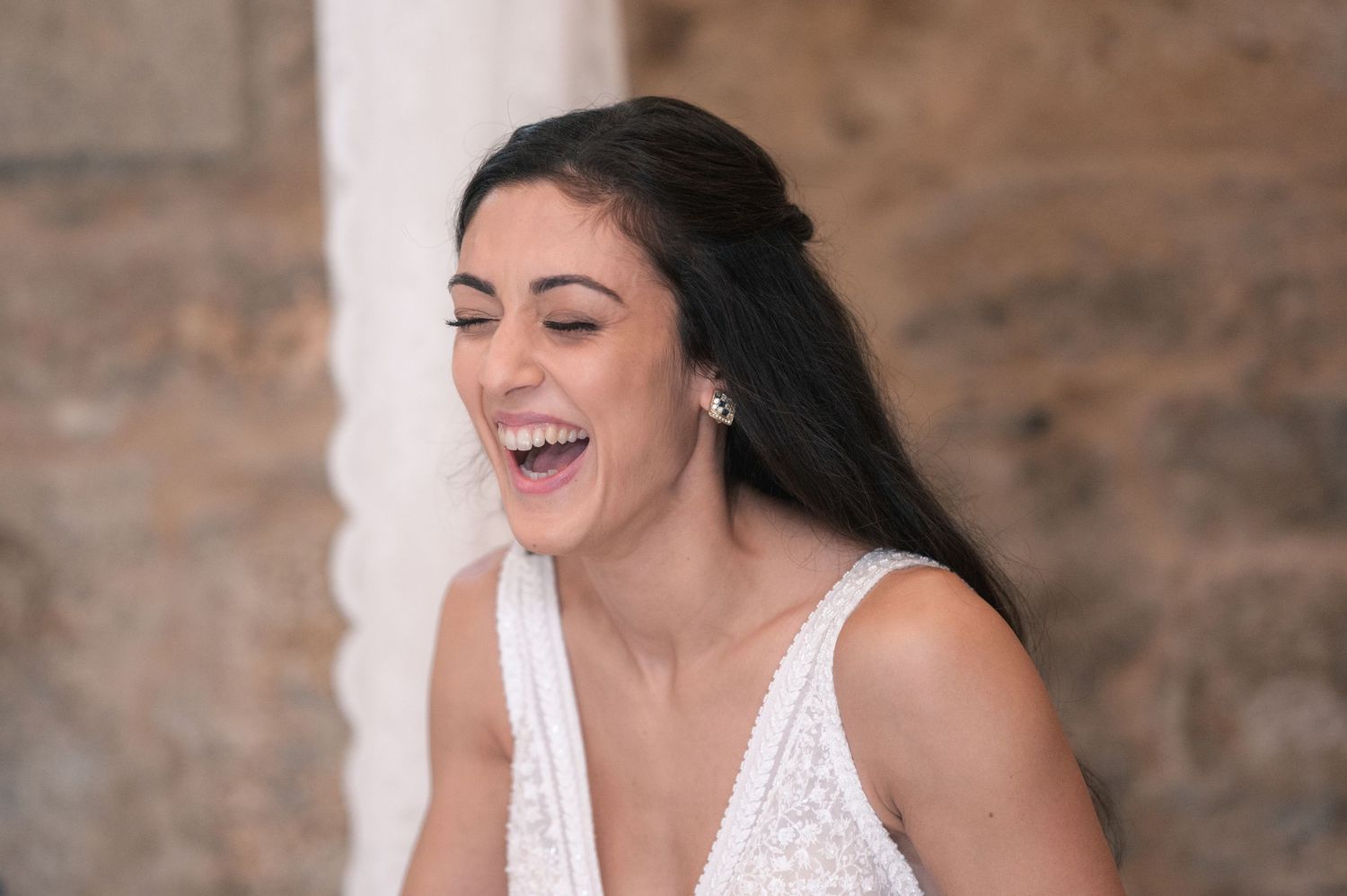 Natural moments of happiness captured in a sequence against stone walls.