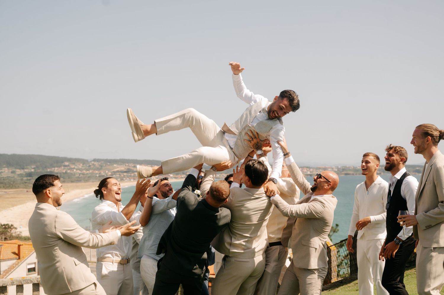 A sequence of wedding party members jumping joyfully against a scenic mountain backdrop on a sunny day.