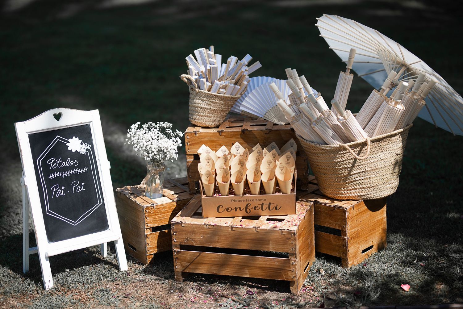 Rustic wooden crates and boxes arranged with white floral decorations and chalkboard signs for a vintage-style event display.