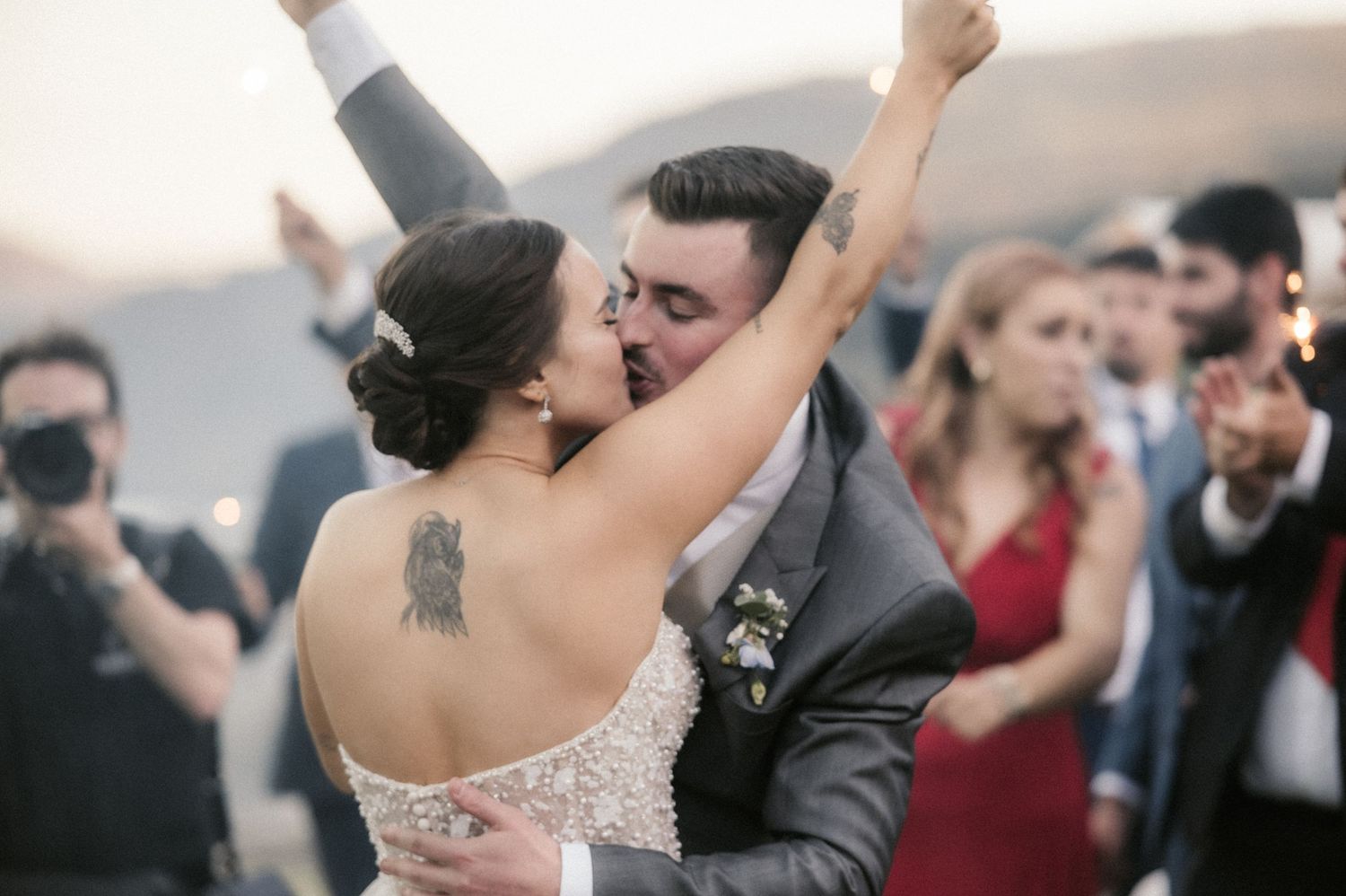 Wedding guests dance and celebrate joyfully on a crowded dance floor during an evening reception.