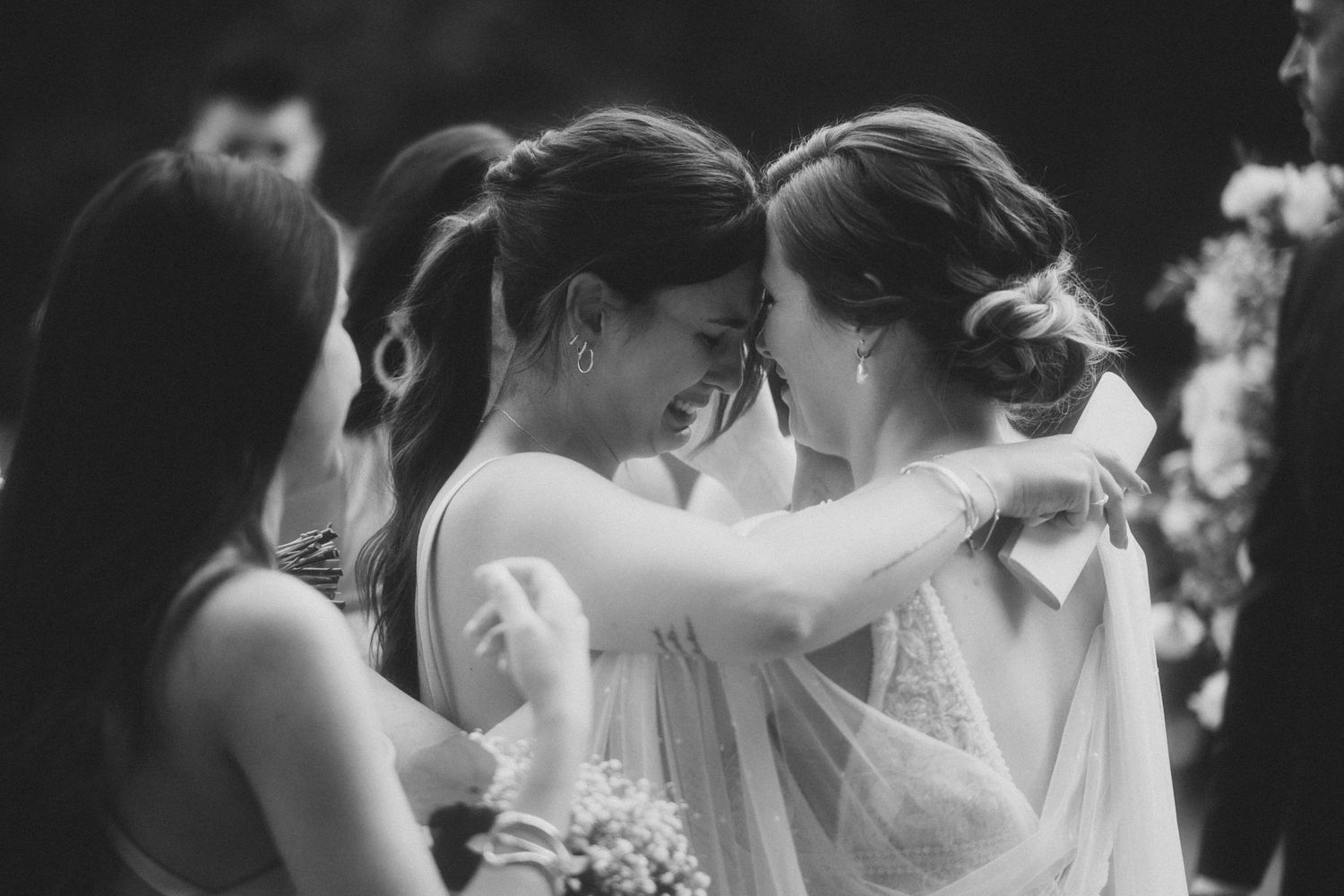 A bride and groom share an intimate moment during their wedding ceremony in black and white photography.
