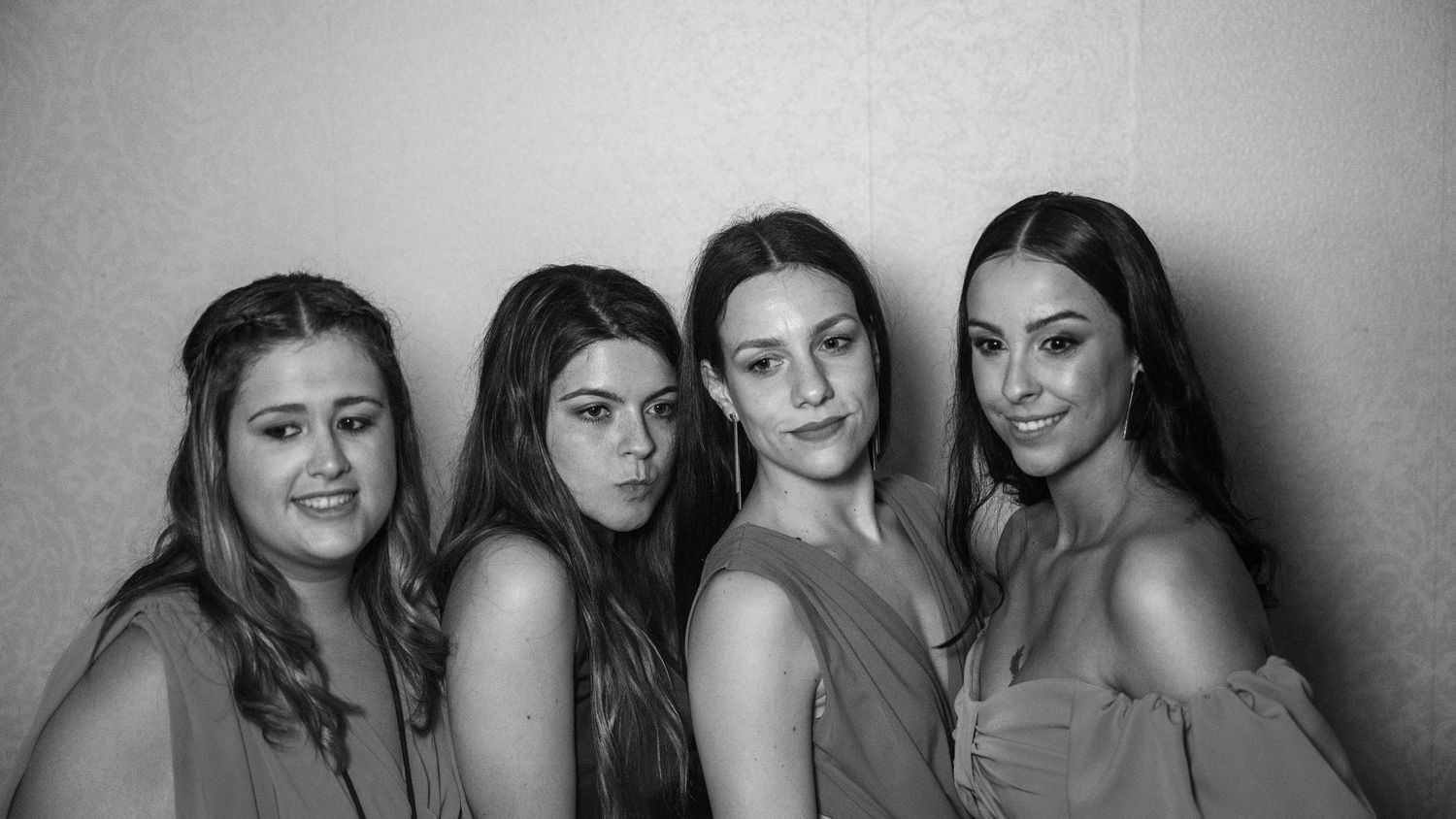 A black and white group photo showing several people lined up against a plain background.