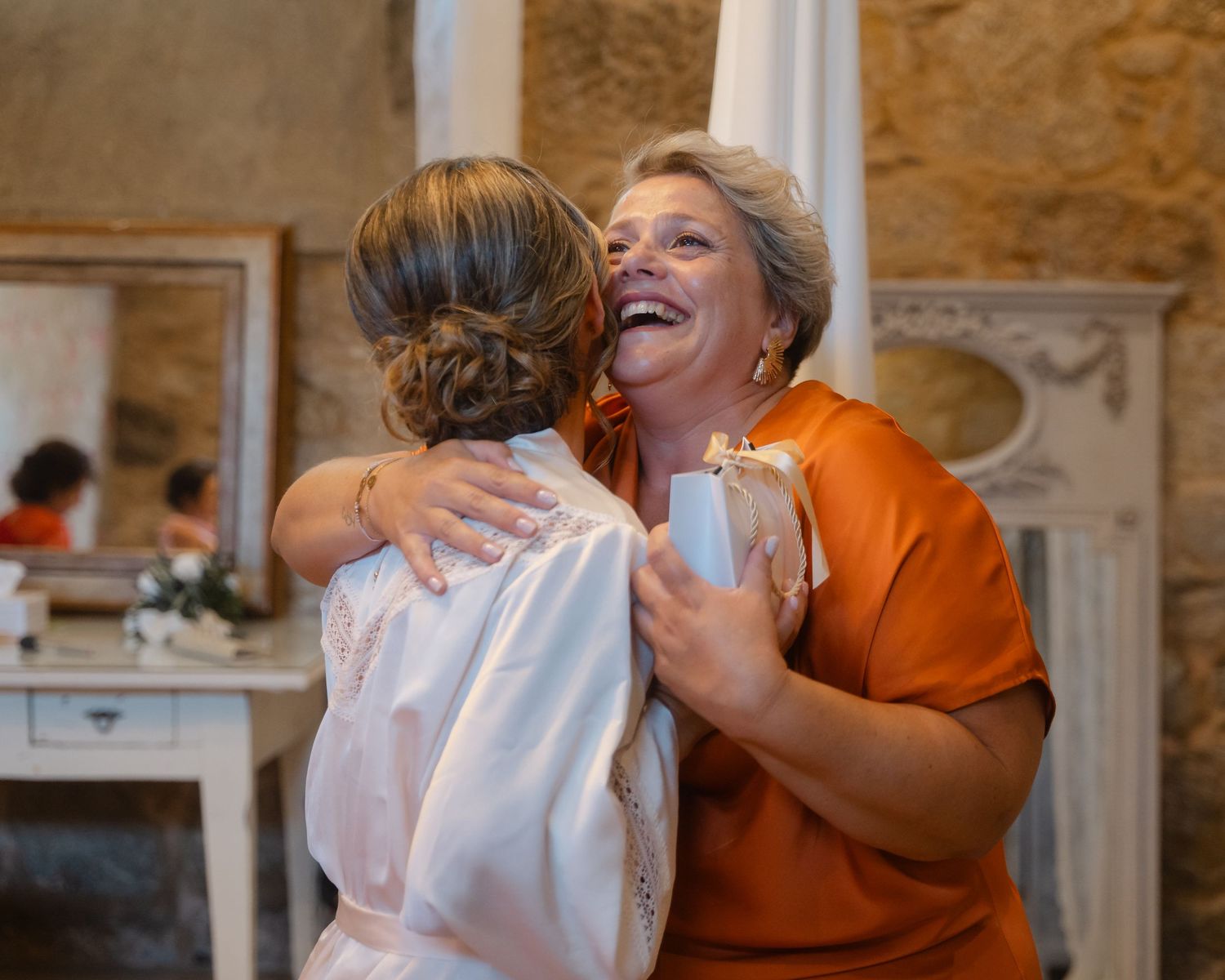 People sharing emotional embraces during what appears to be a wedding celebration.
