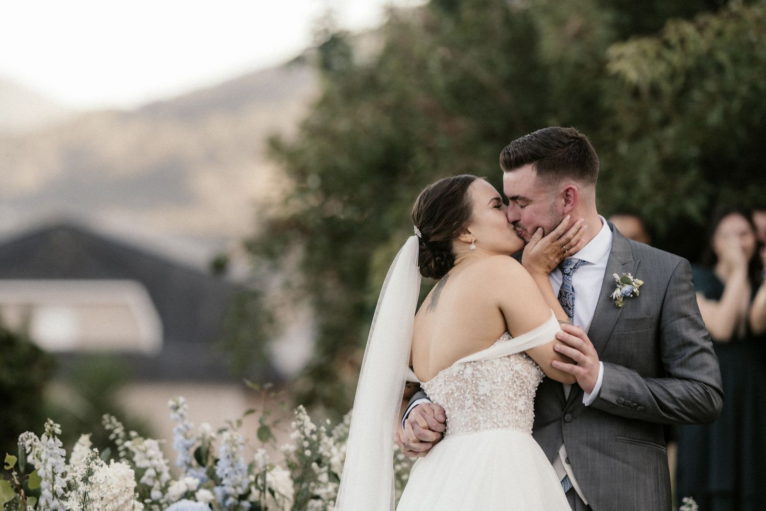 A tender moment between newlyweds embracing during their outdoor wedding ceremony.