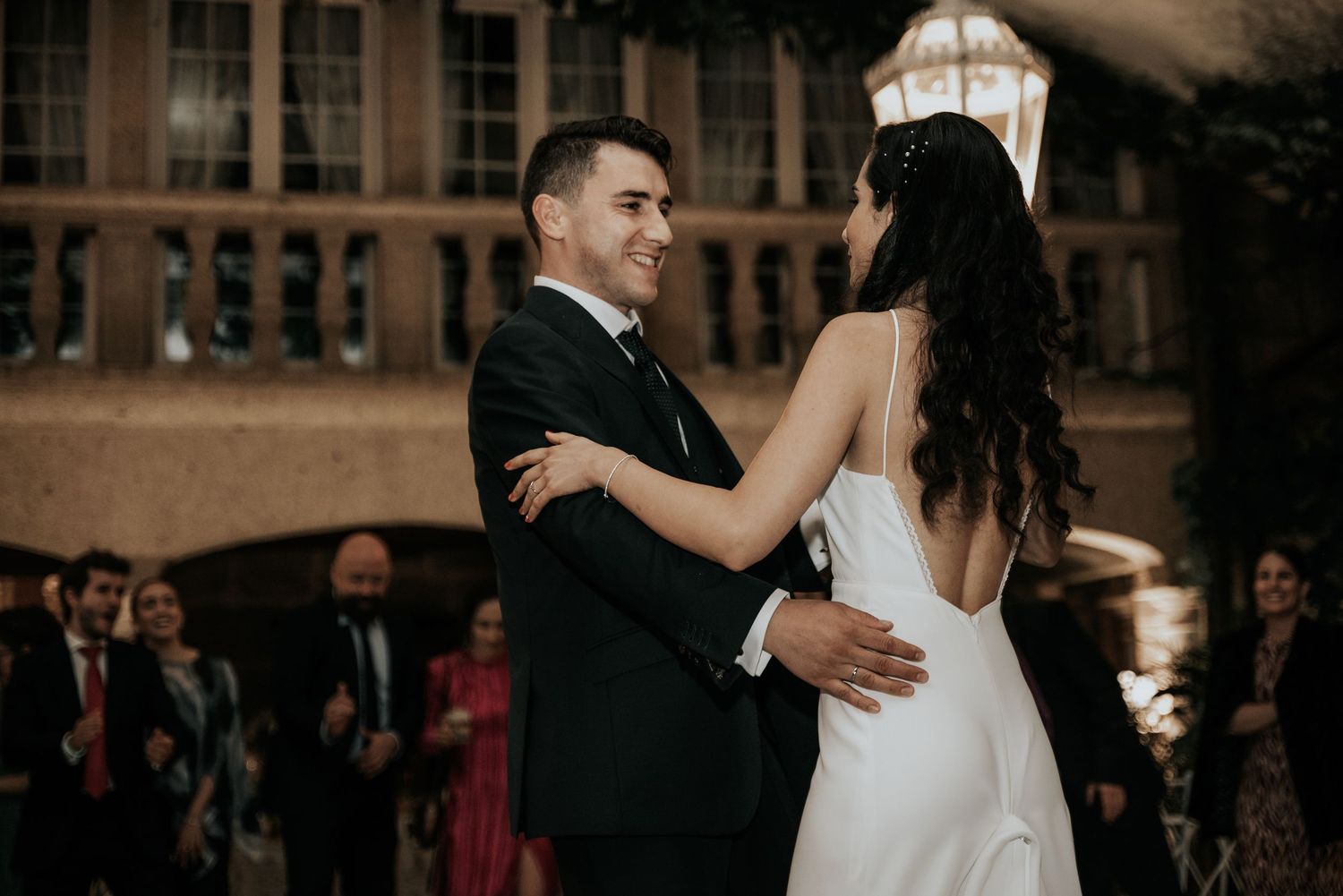 Wedding guests dance together during a romantic evening reception celebration.