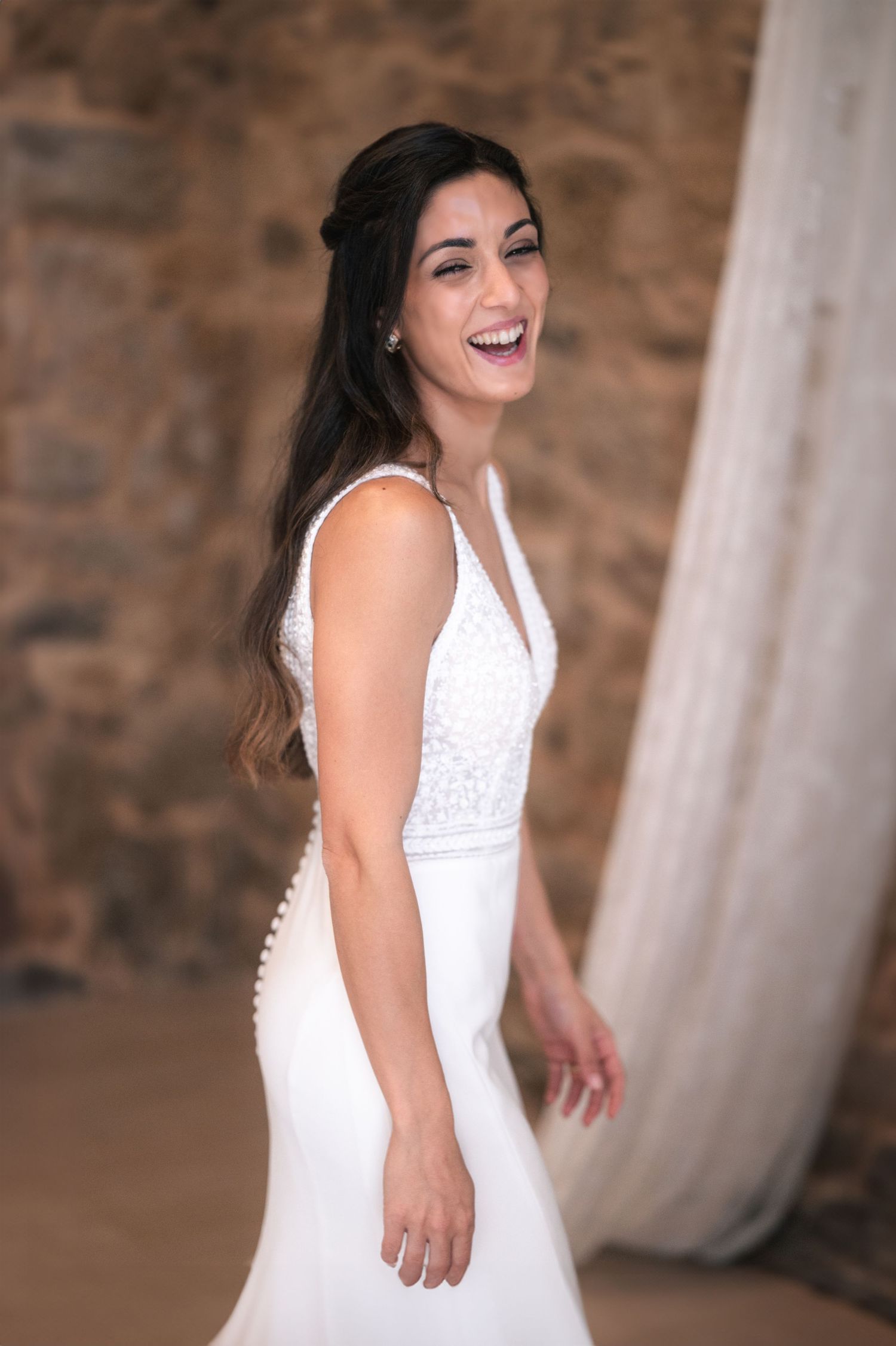 Dancing and spinning sequence in a white wedding dress against rustic stone walls.
