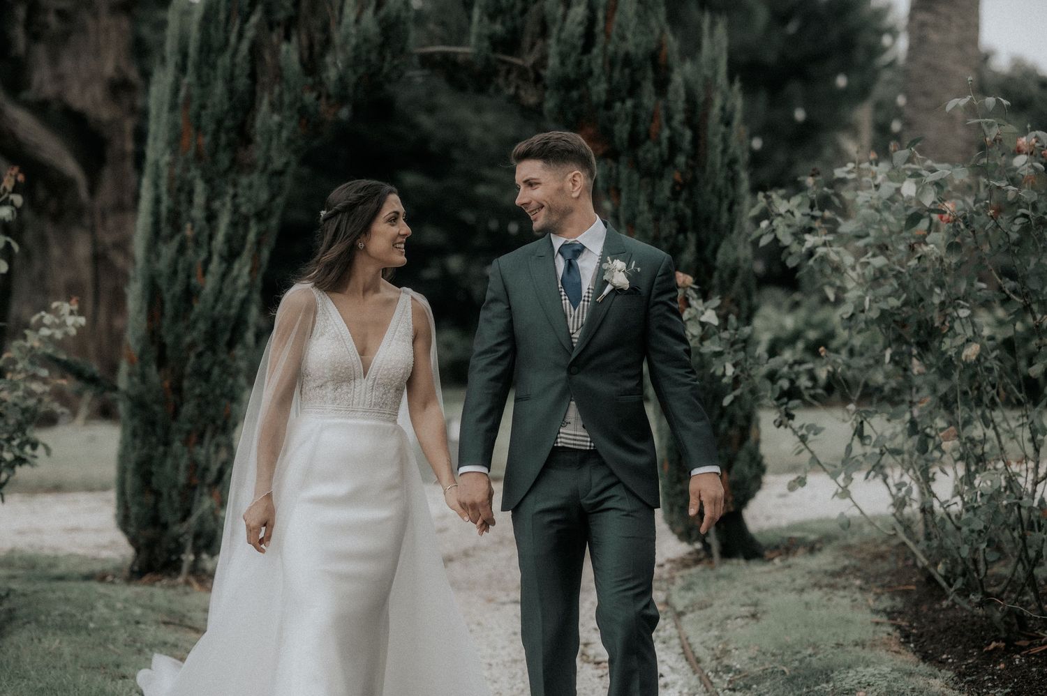 A bride and groom share intimate moments in a lush garden setting during their wedding photoshoot.