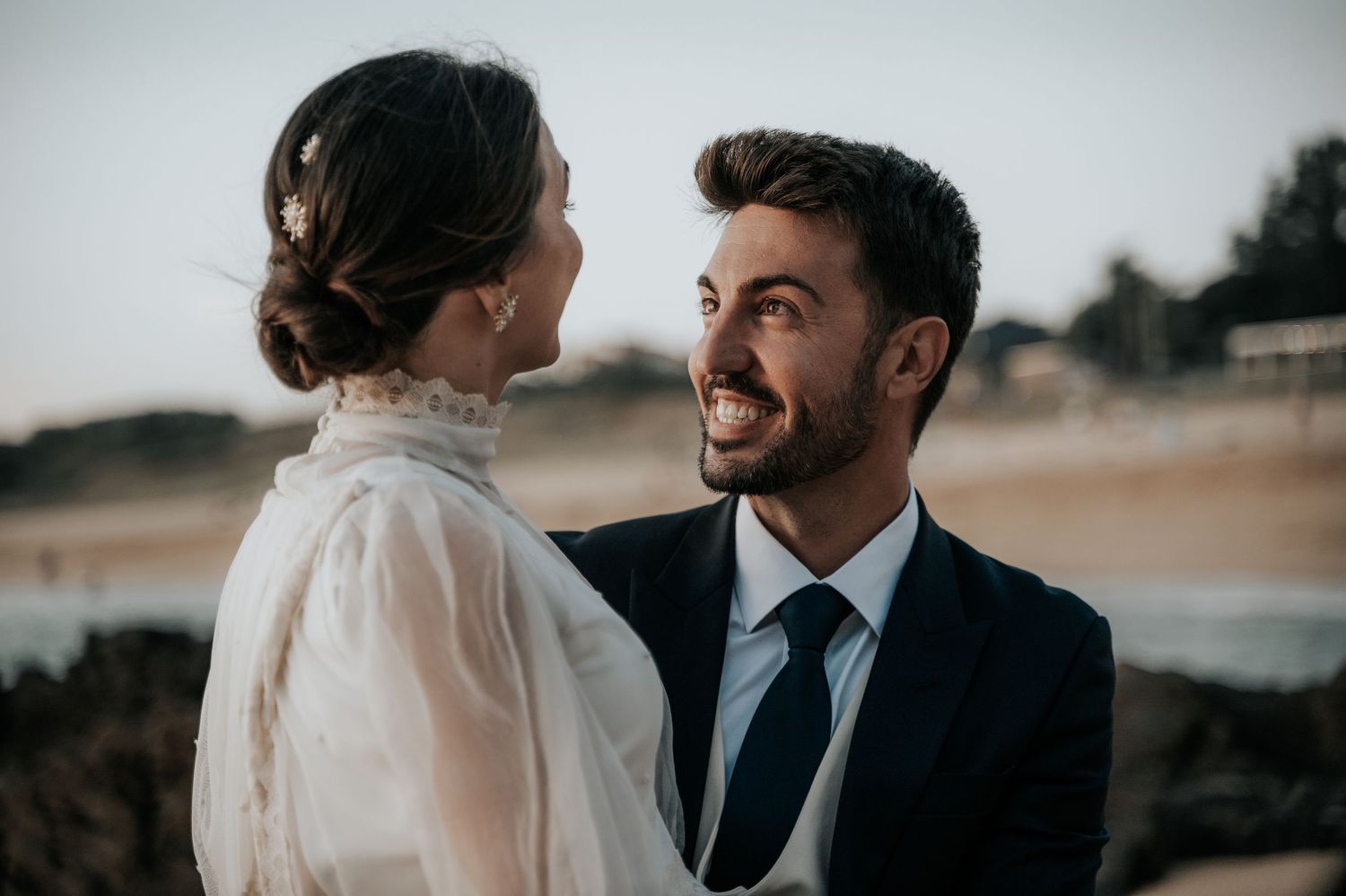 Newlyweds share intimate moments during a coastal wedding photoshoot.