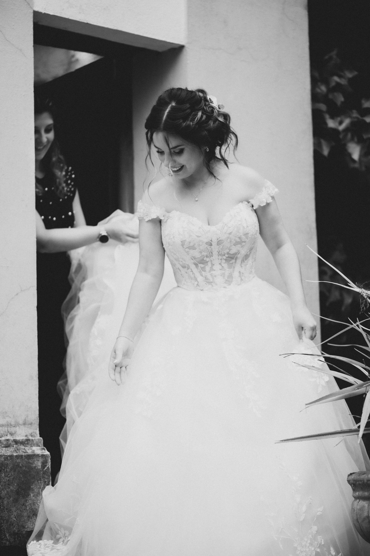 Close-up details of a flowing white wedding dress with delicate lace and tulle fabric.