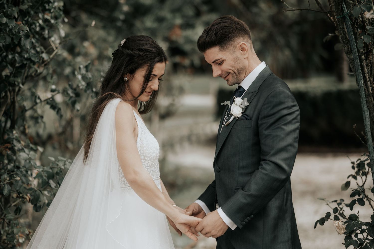 Elegant outdoor wedding moment captured with couple in formal attire surrounded by natural garden scenery.