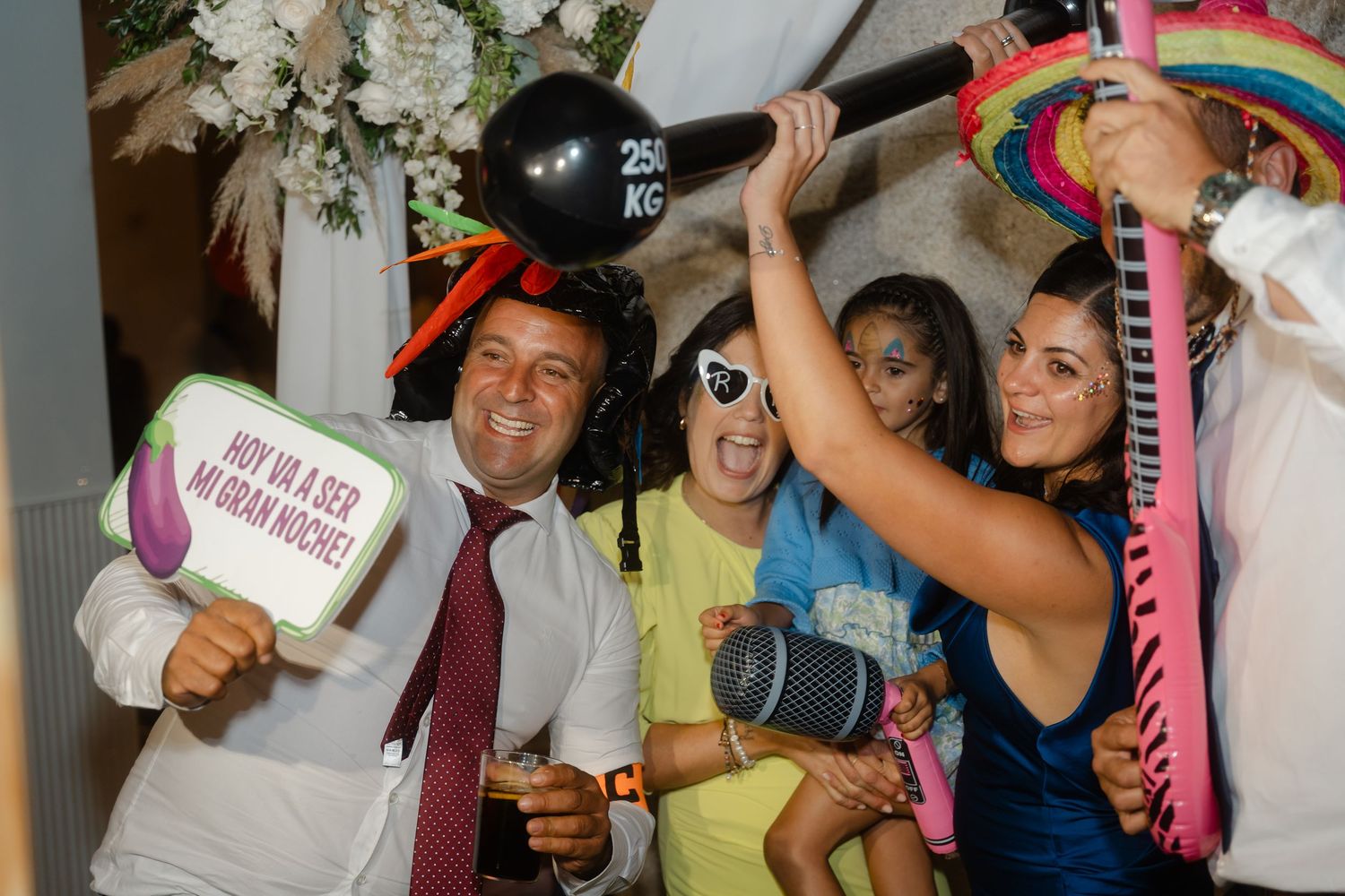 Party guests dance and celebrate with colorful glow sticks and accessories at a lively indoor celebration.