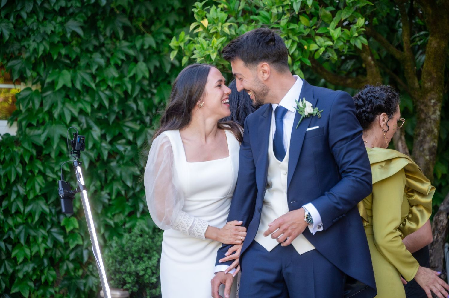 Newlyweds sharing intimate moments against a backdrop of lush green foliage.
