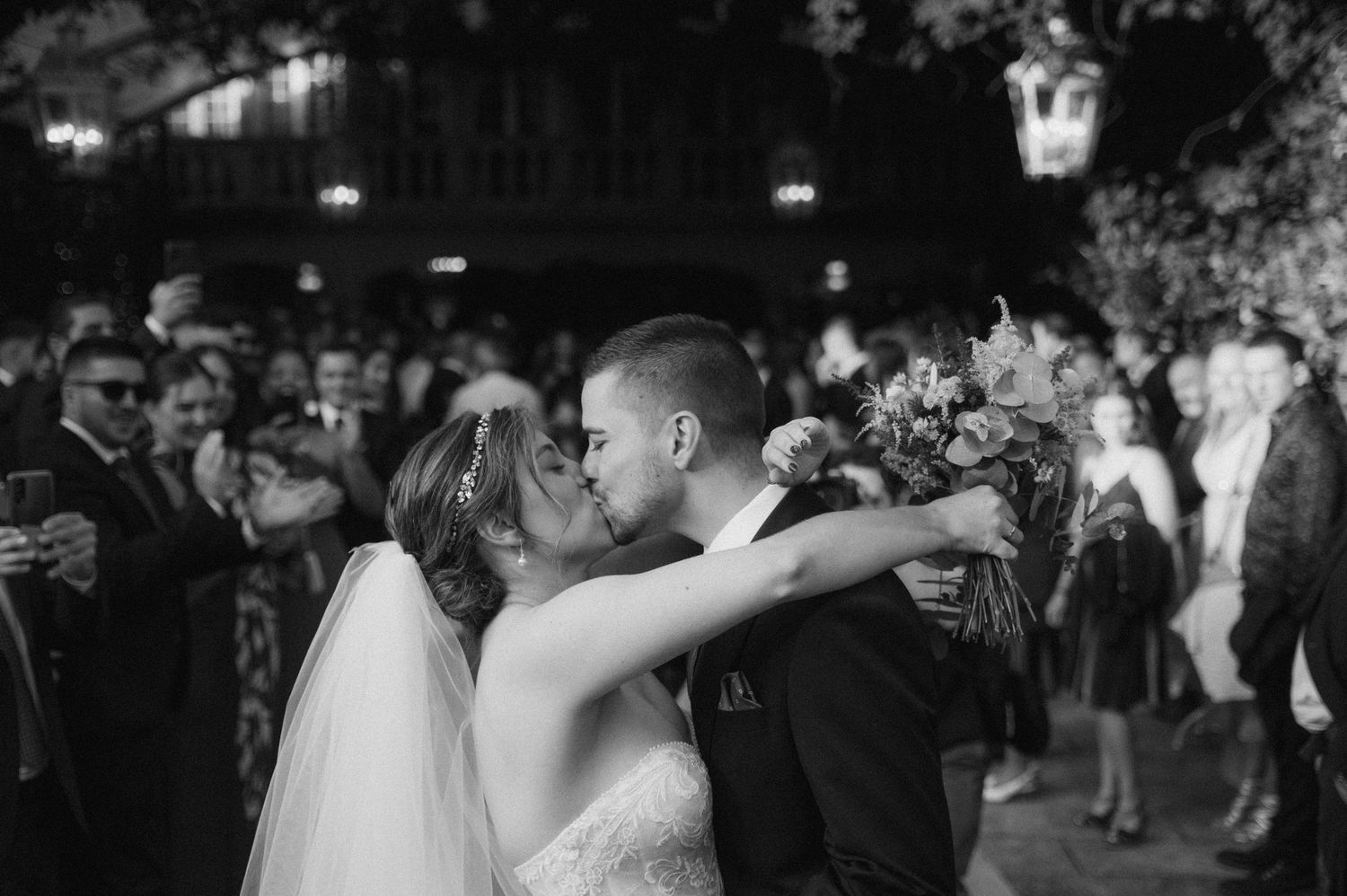 Couples dancing together at an evening wedding reception with string lights overhead.
