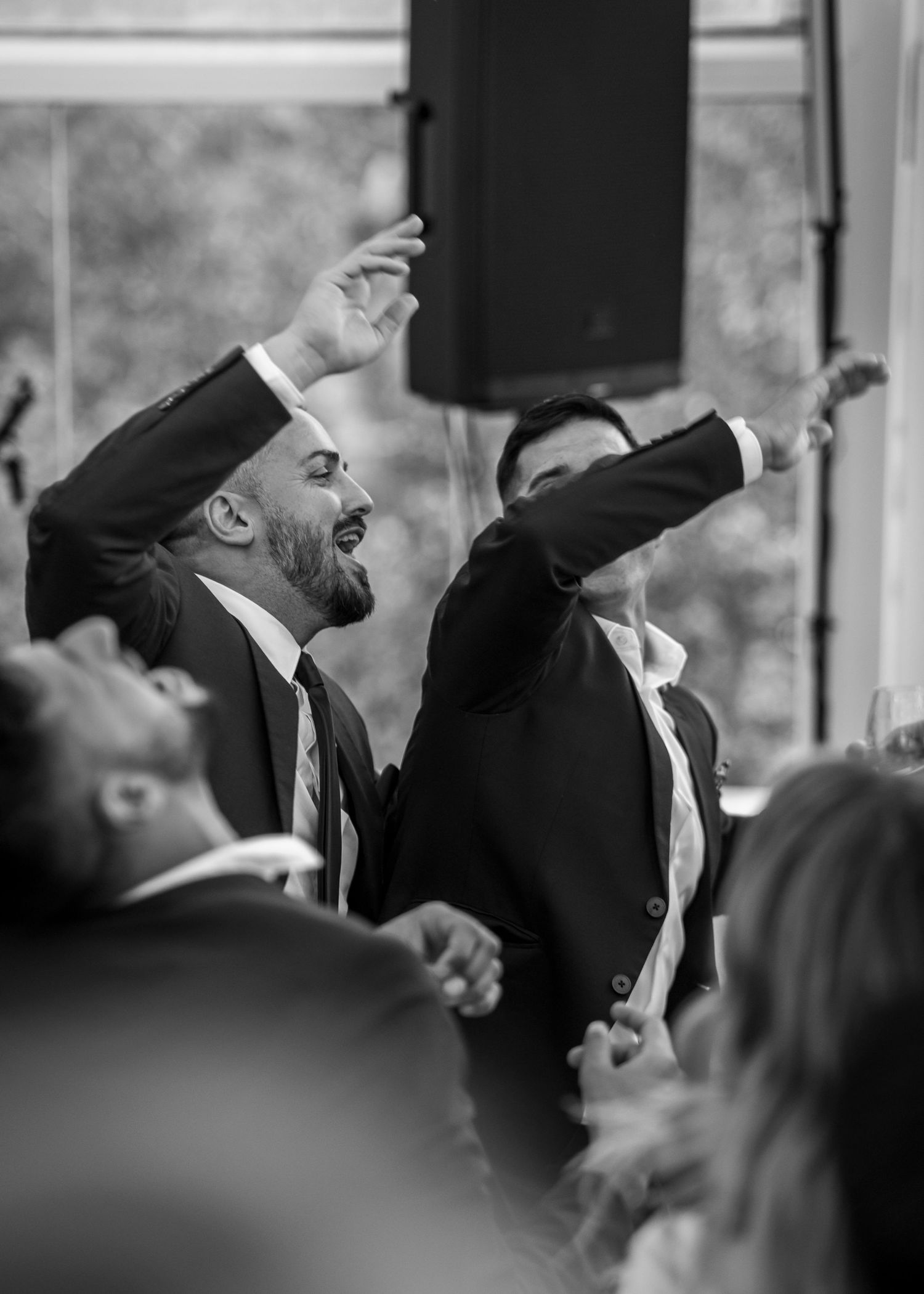 A black and white photo series shows groomsmen performing synchronized dance moves at a wedding reception.