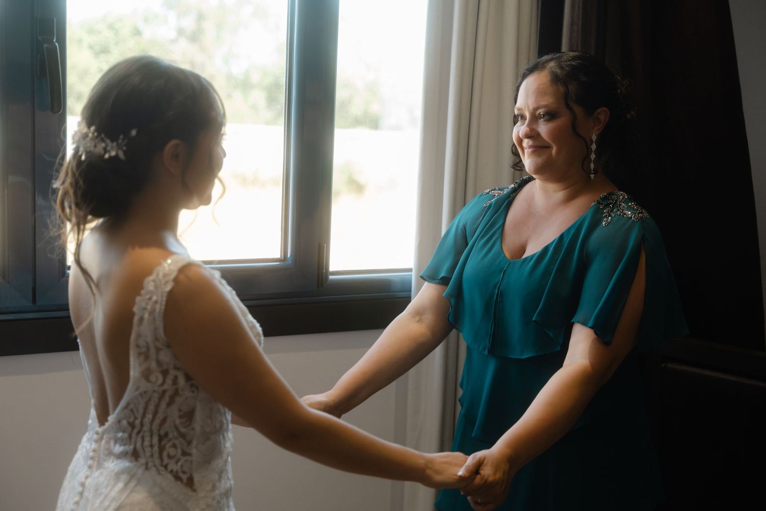 Two figures in silhouette stand together near a bright window in an intimate moment.