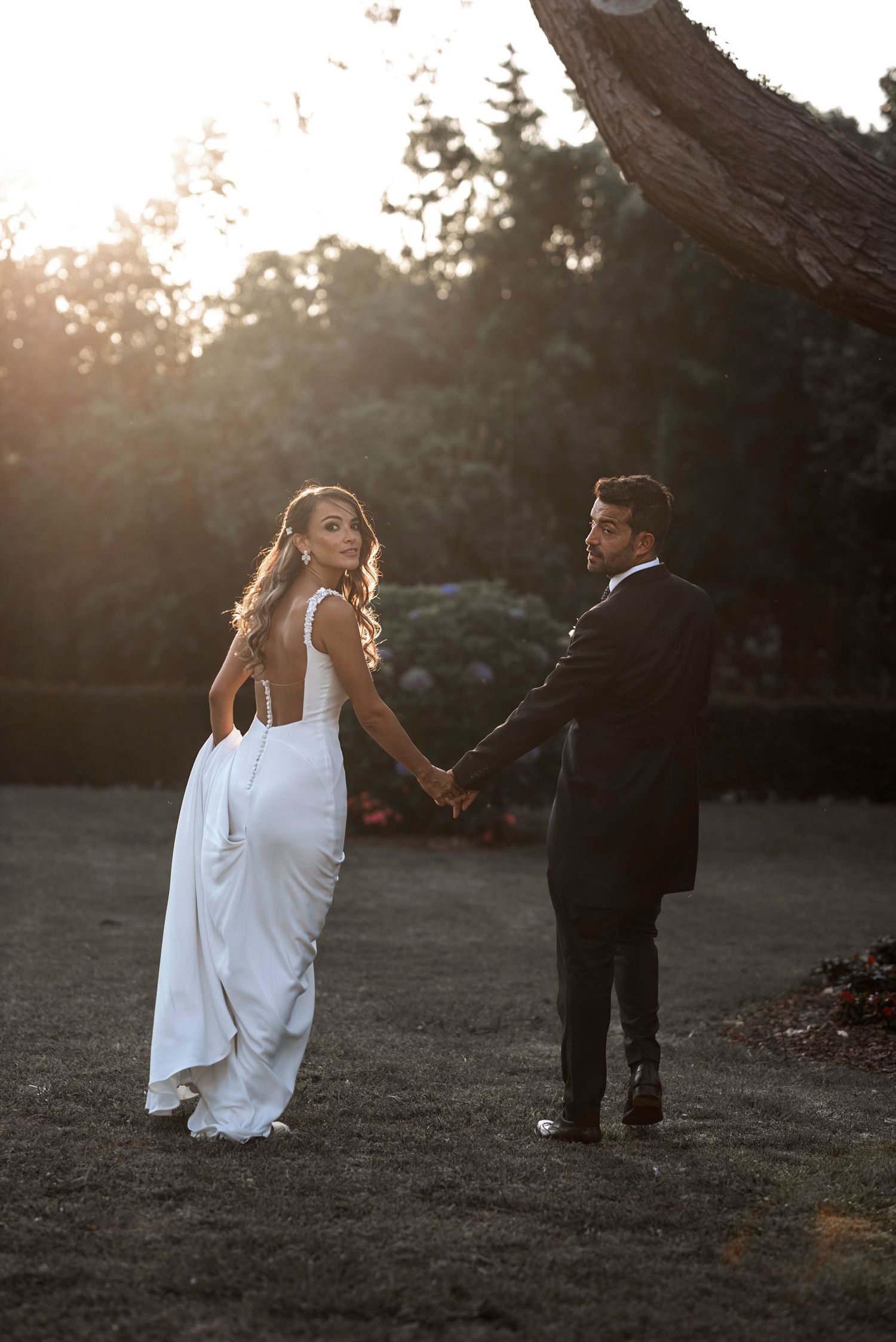 Sunset wedding photoshoot with couple walking through a scenic outdoor setting.
