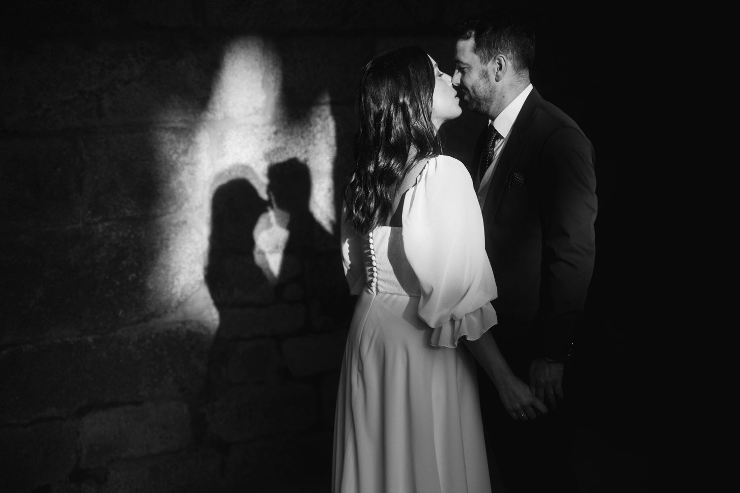 Black and white wedding photographs showing romantic moments between newlyweds in an artistic collage.