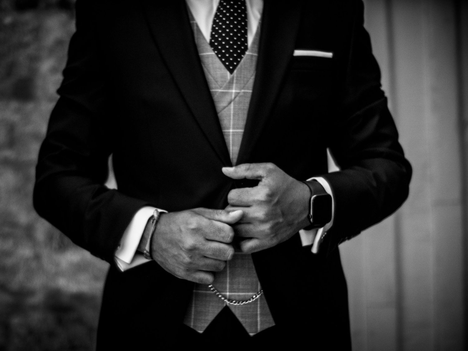 Close-up view of men's formal attire showing polka dot tie and suit details.