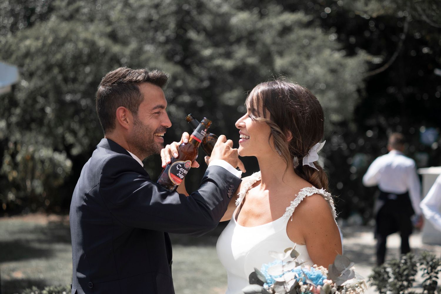 A couple shares a romantic moment drinking champagne together during an outdoor wedding celebration.