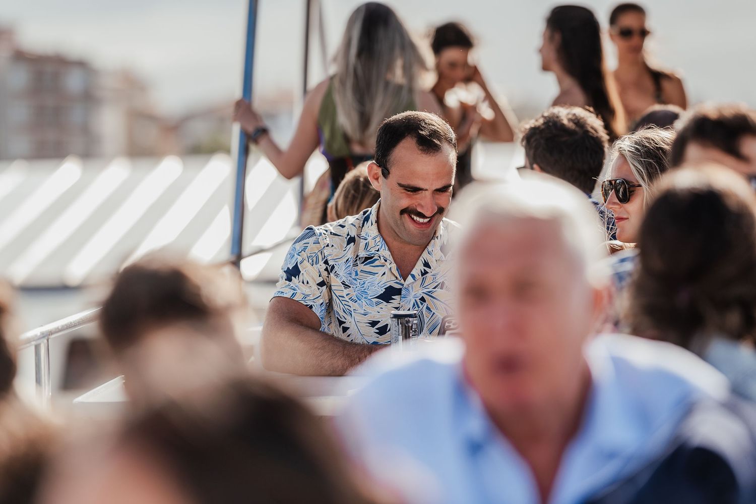 Crowd of guests mingling at a sunny outdoor social gathering or celebration.