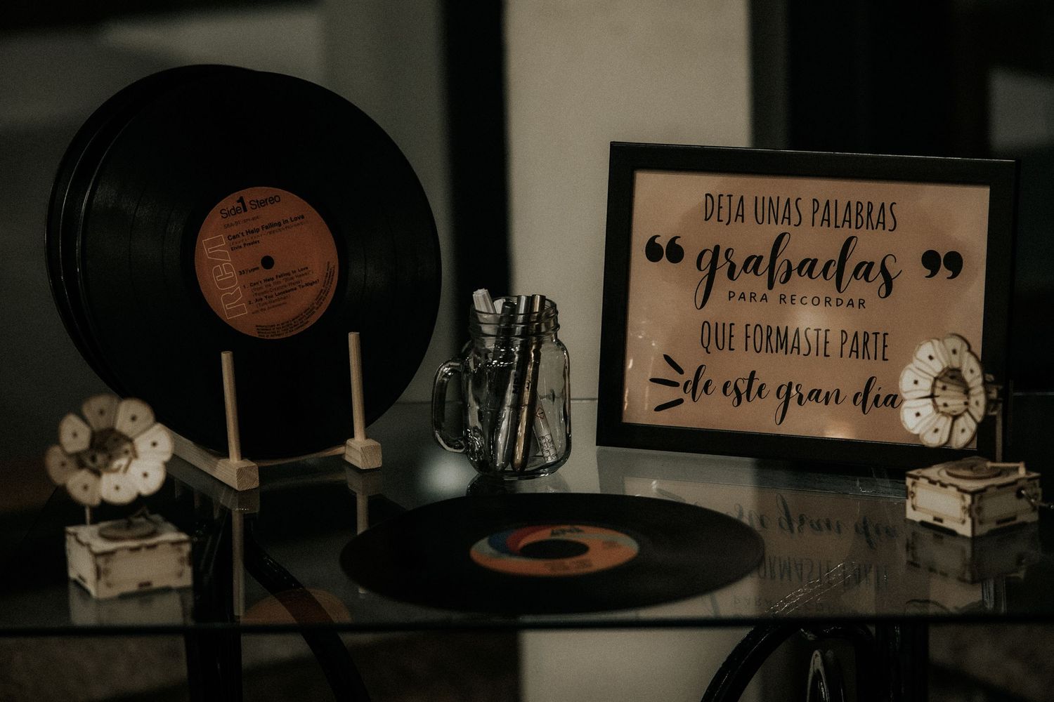 Vintage vinyl records and turntable equipment arranged in moody dark lighting with rustic decor elements.