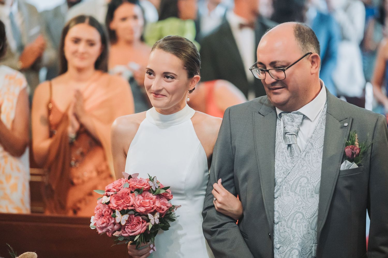 Joyful wedding guests celebrate during a reception with warm lighting and festive atmosphere.