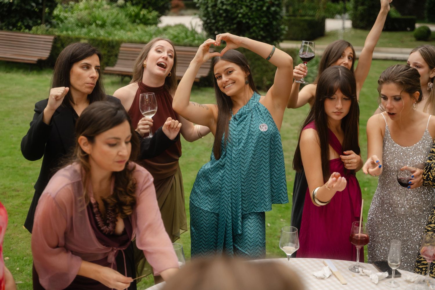 A group of friends enjoying a lively celebration outdoors with dancing and laughter.