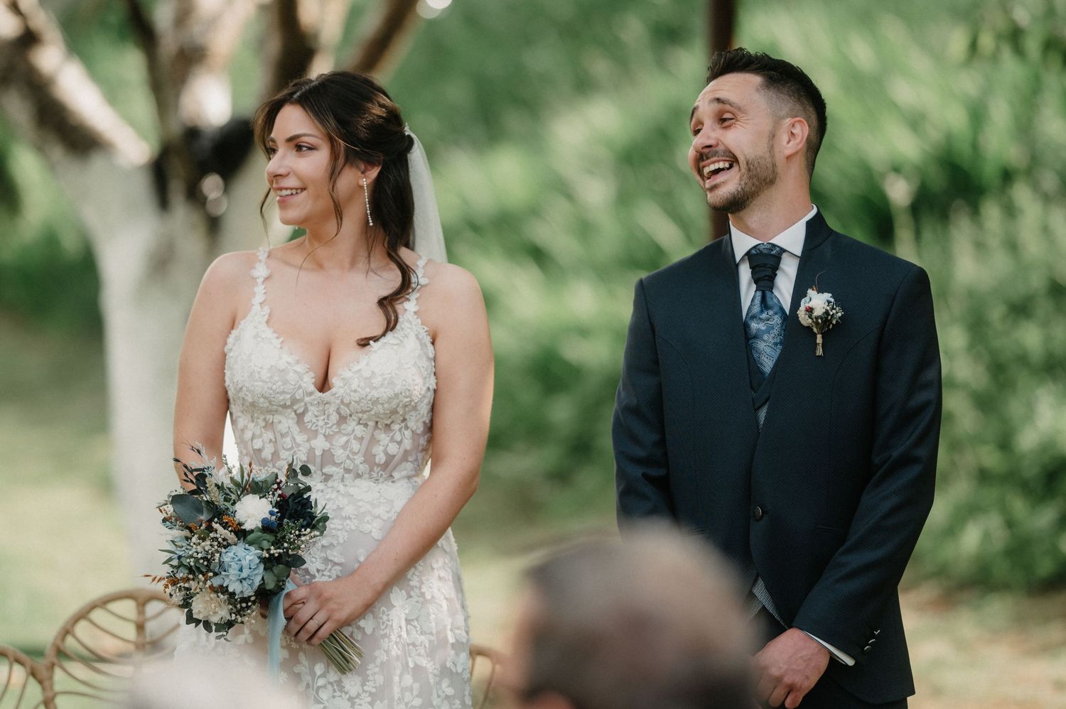 Wedding couple seated outdoors during their garden ceremony.