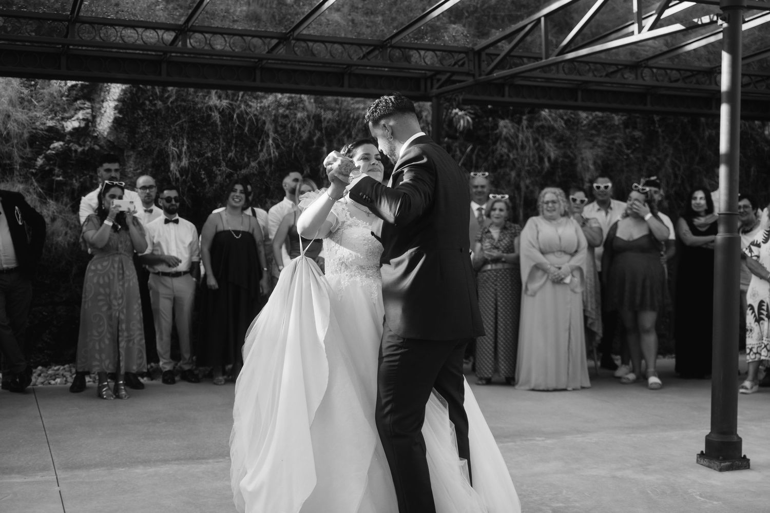 Wedding guests dance together in formal attire during an elegant outdoor reception celebration.