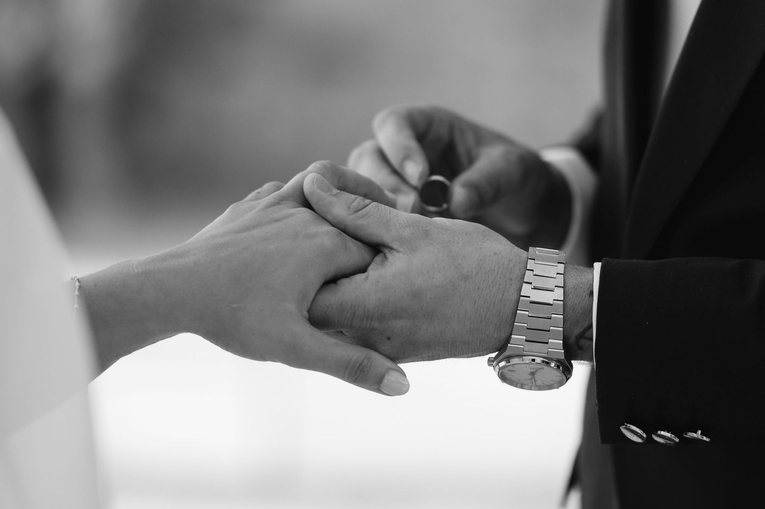 Close-up of hands signing documents with a pen during a business meeting or contract signing.