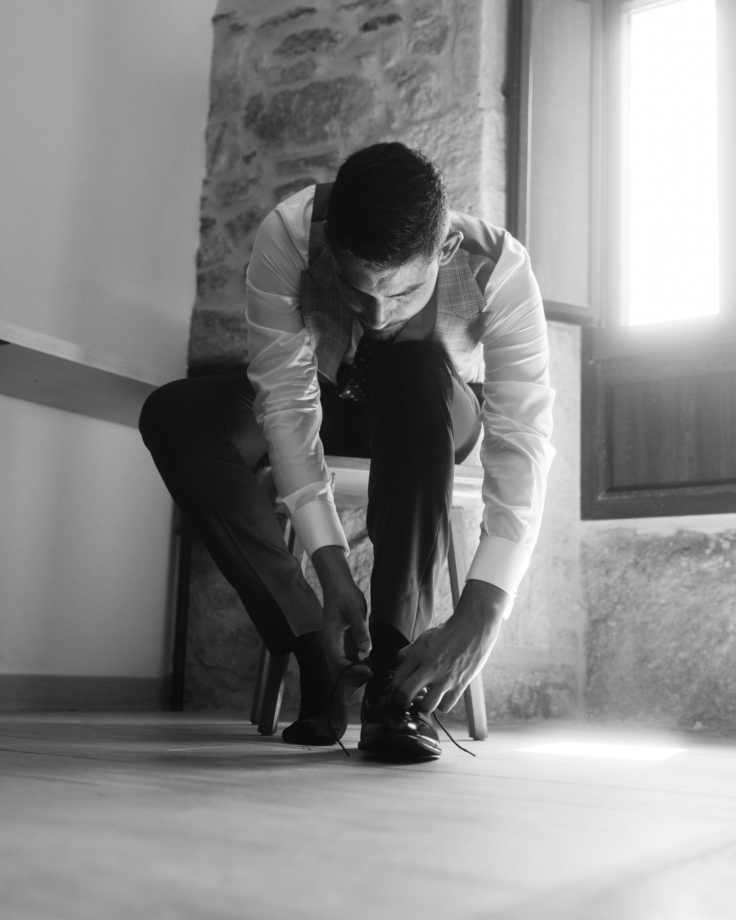 Black and white shots capture intimate moments of formal dressing preparations near a window.