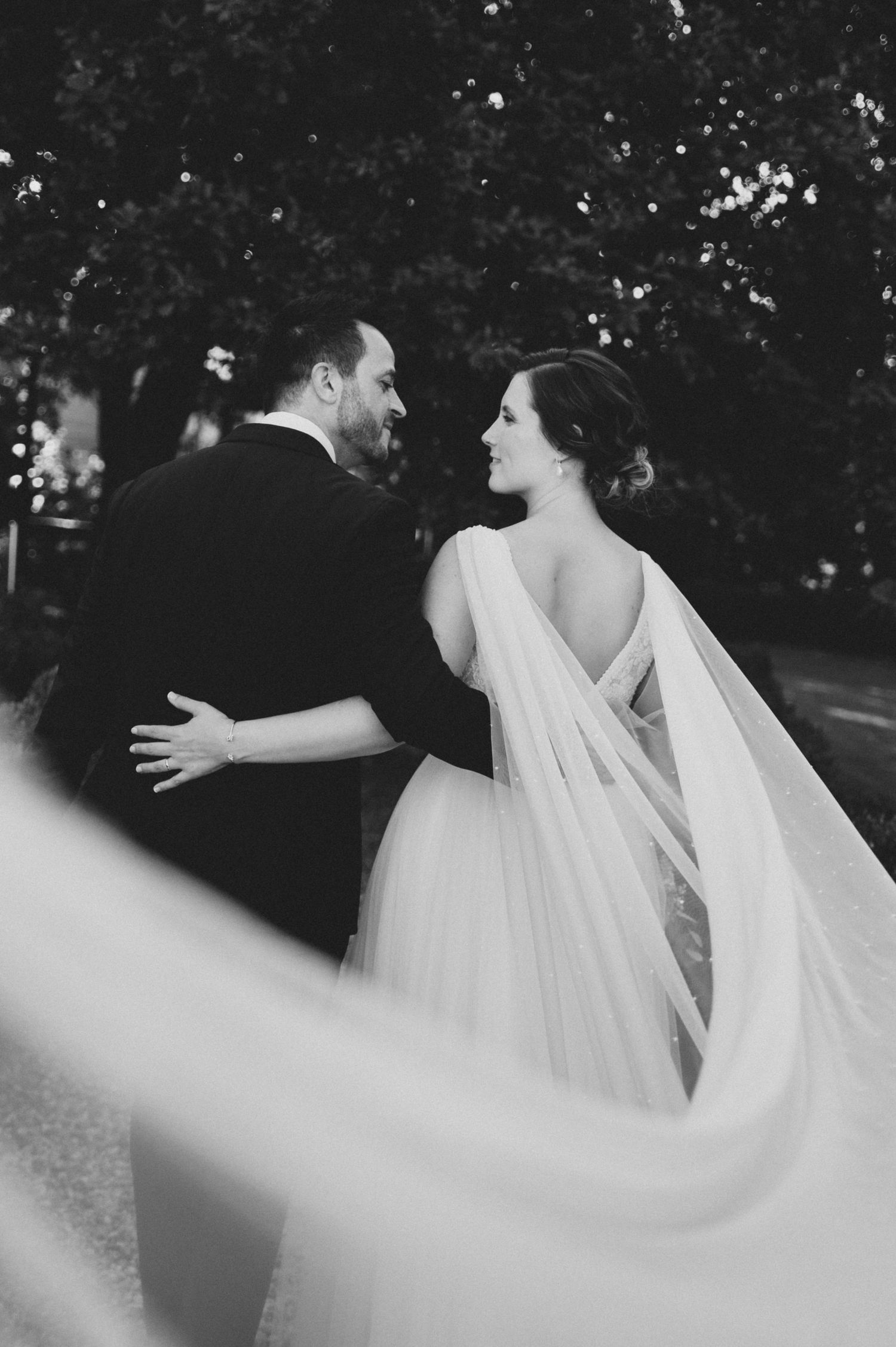 Flowing white wedding veil creates an ethereal effect in black and white wedding photography sequence.