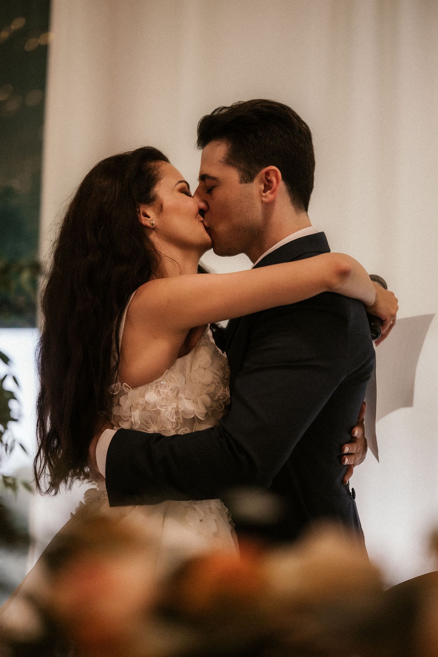 A romantic sequence of wedding photos showing a couple sharing intimate kisses and embraces during their celebration.
