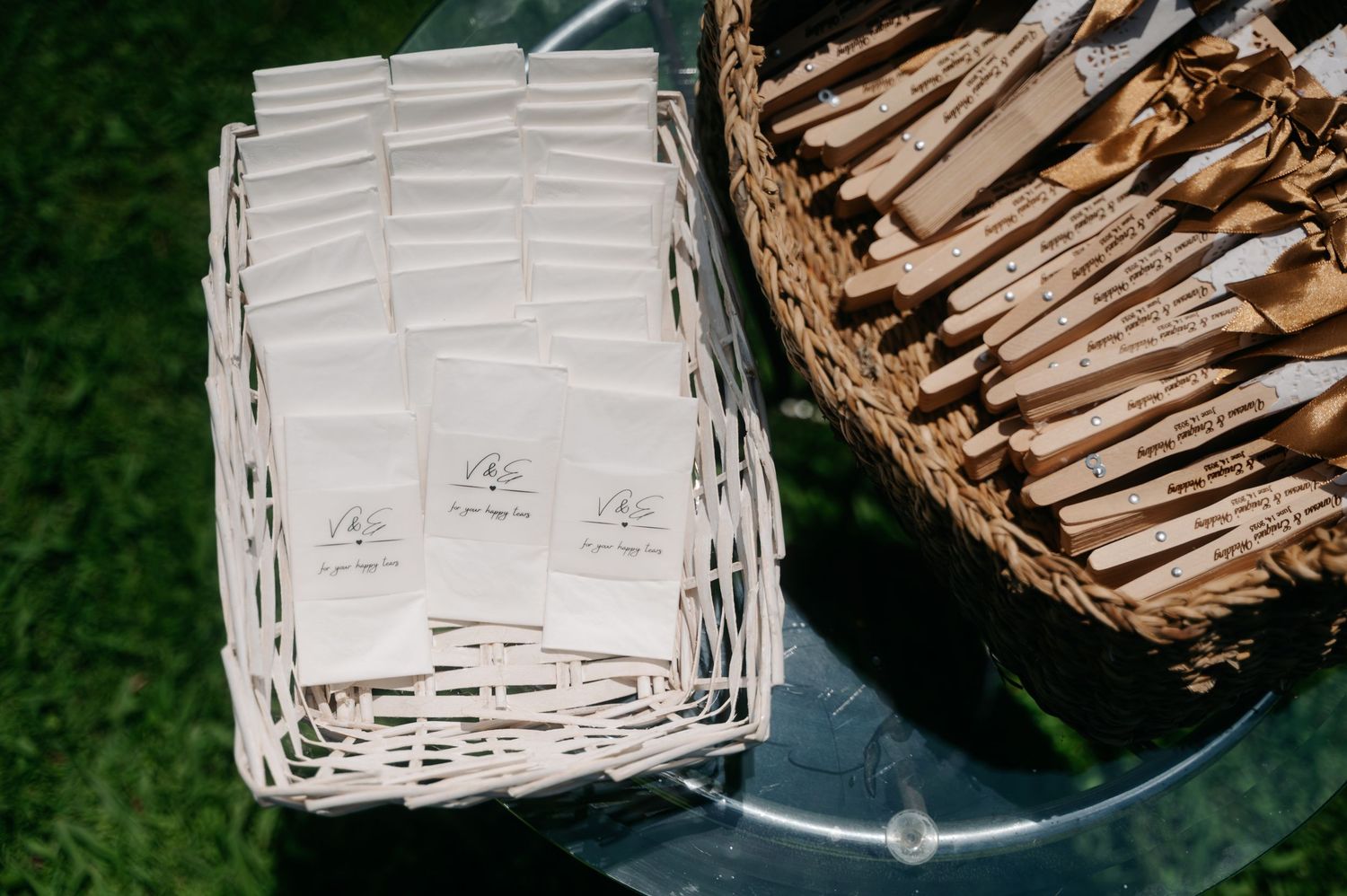 White wicker basket with brown woven handle sits against green background.